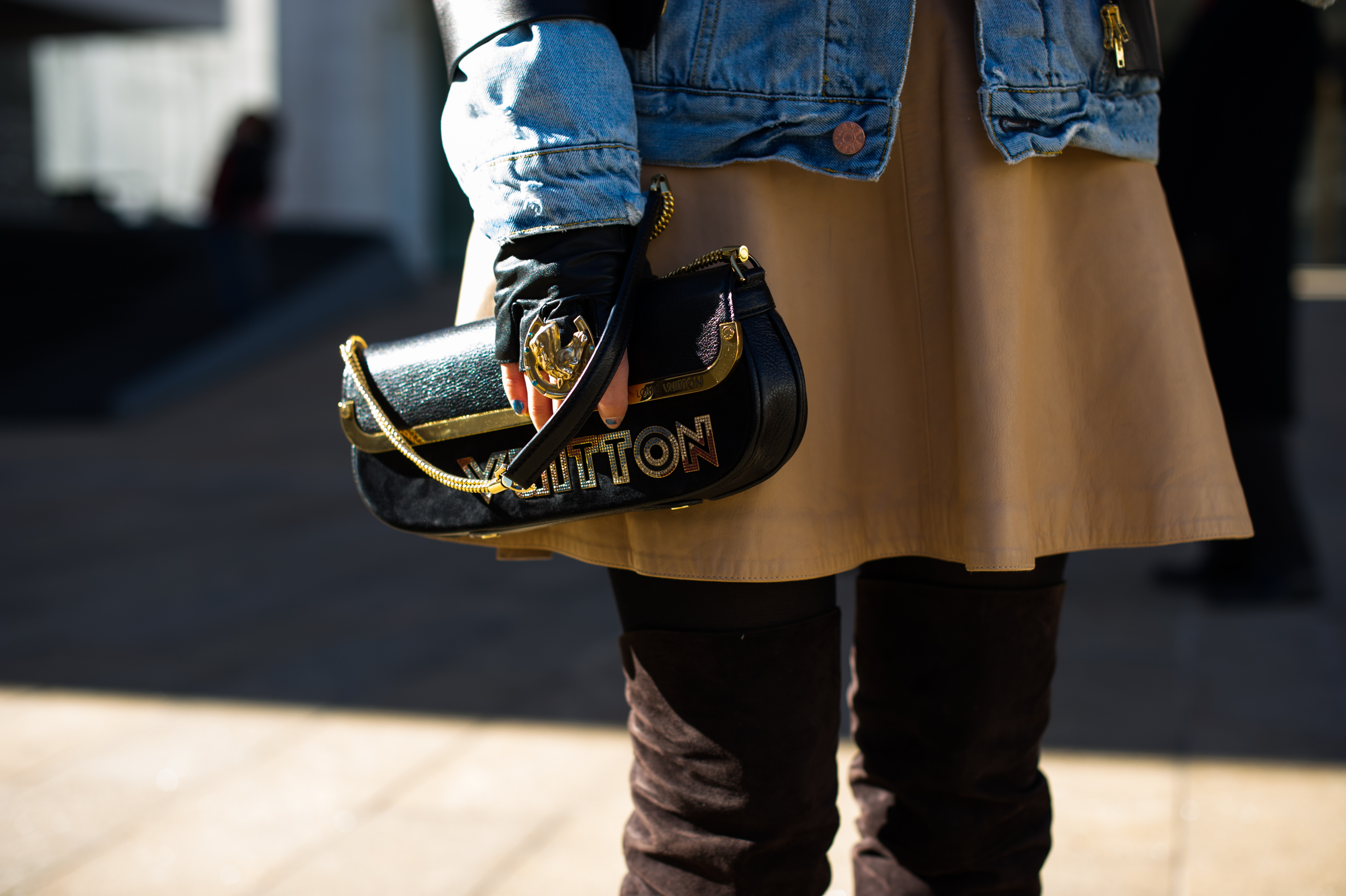 Woman holding Louis Vuitton clutch bag