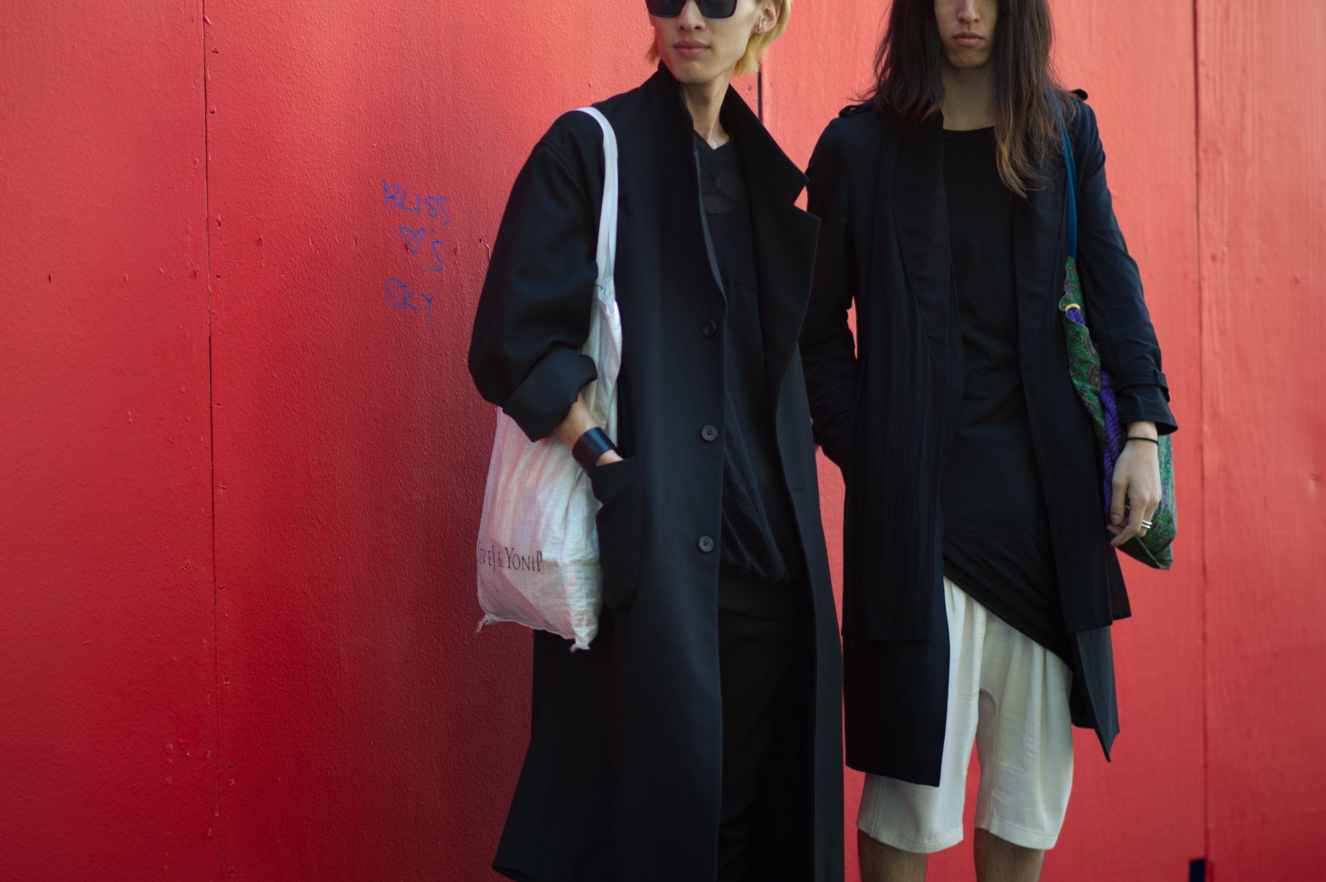 Two photographers in front of wall