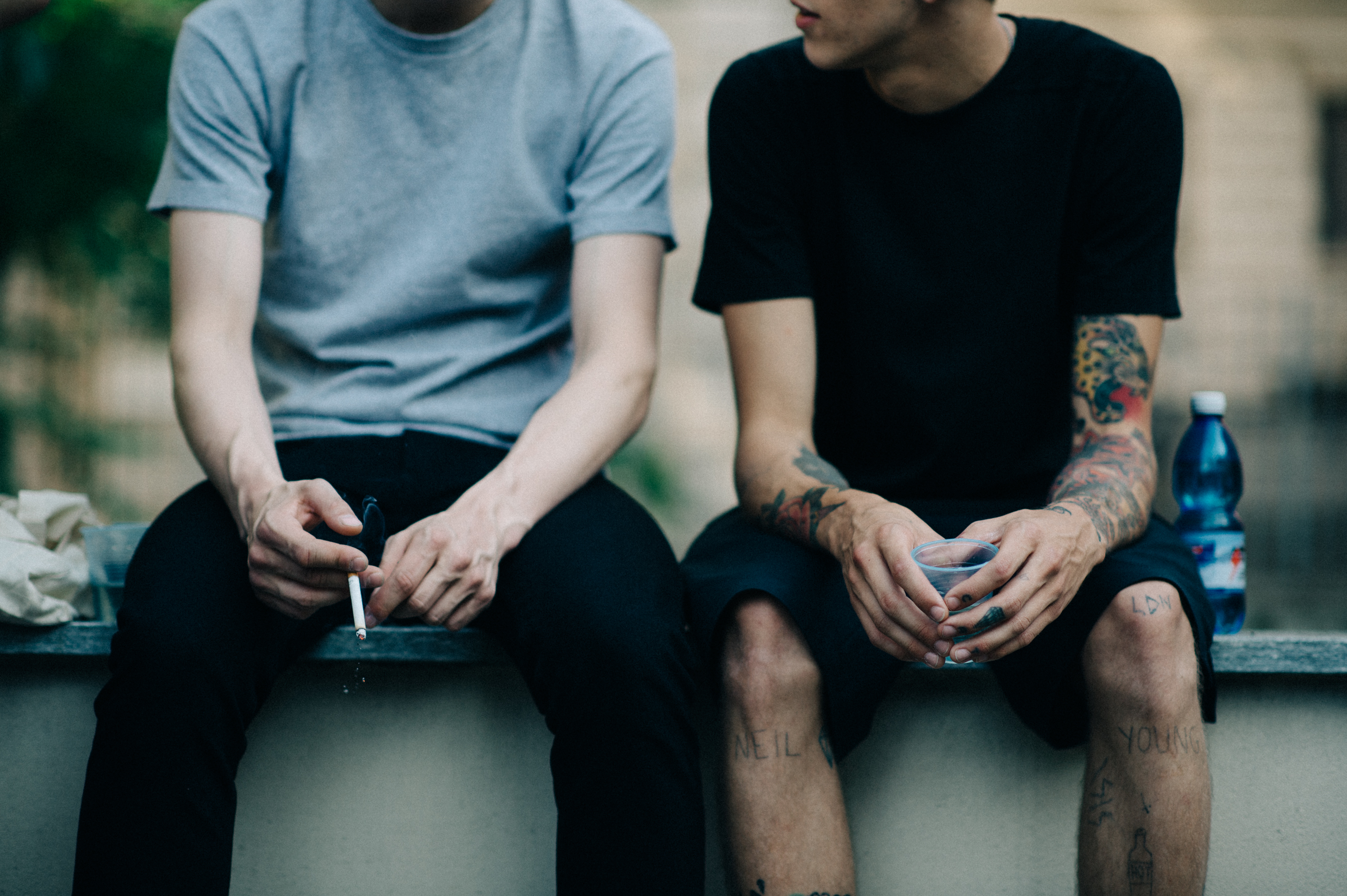 Male models tattooed hands smoking cigarette