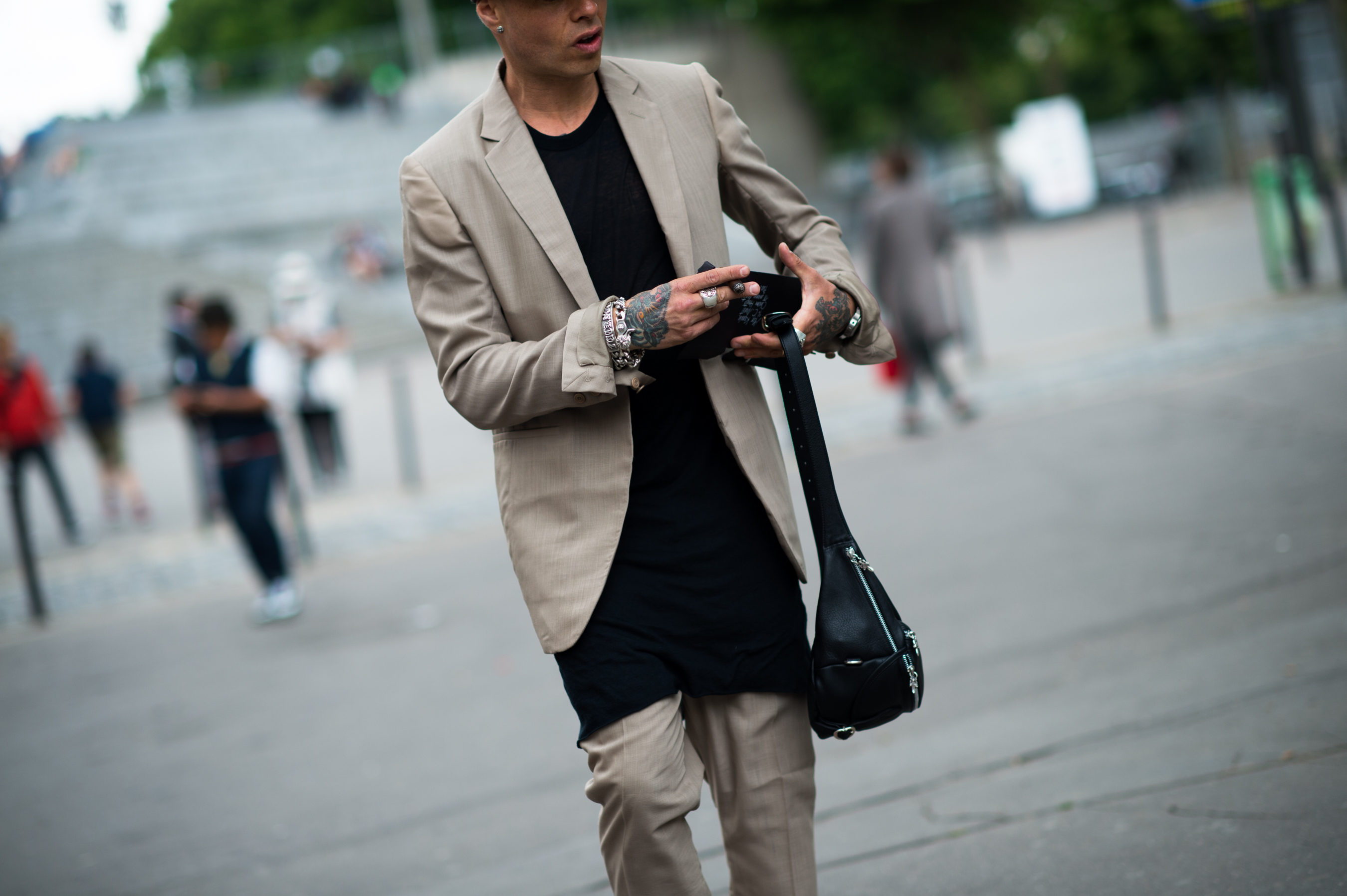 Man wearing tan Rick Owens suit tattooed hands