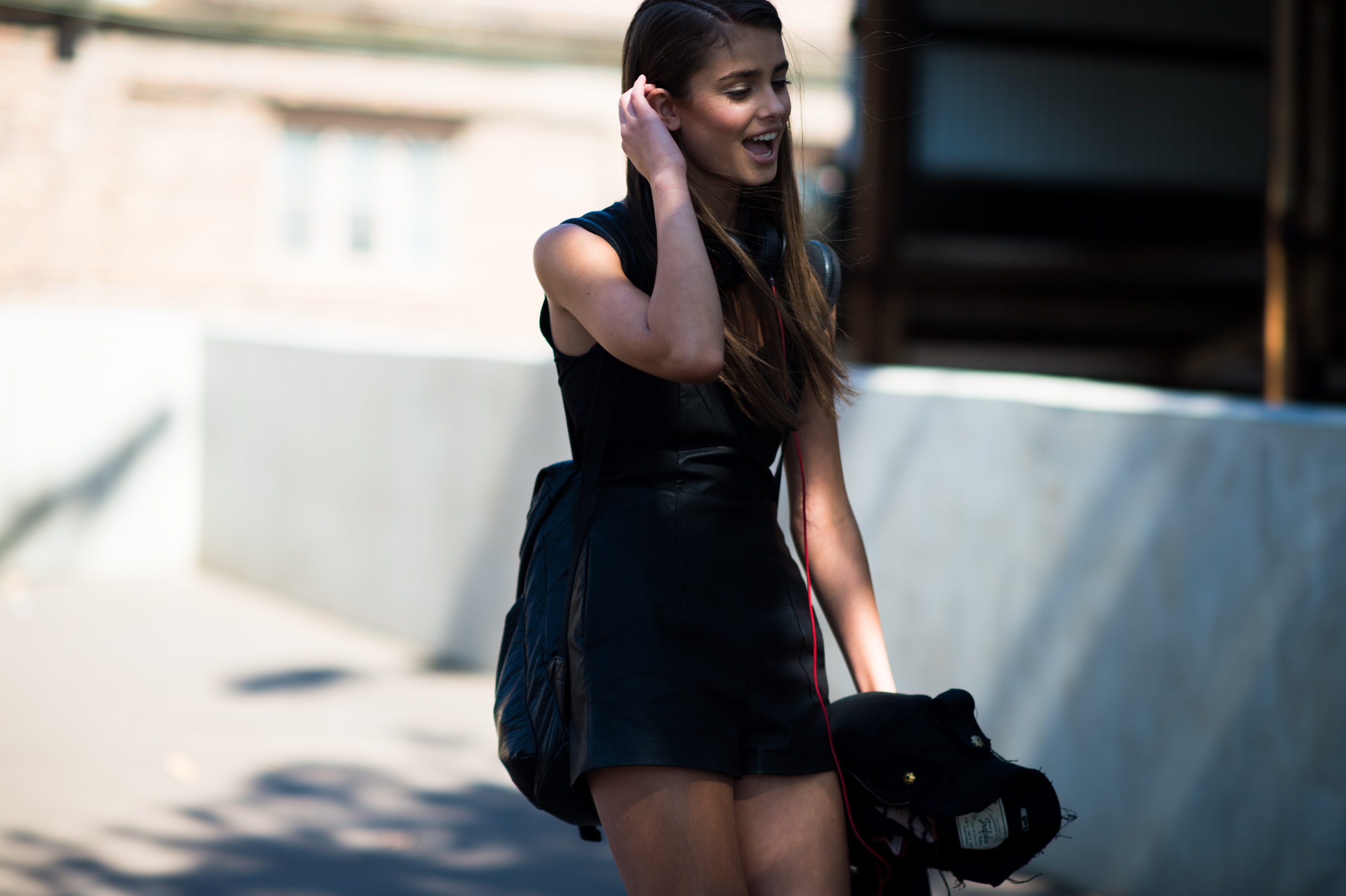 model wearing black leather backpack