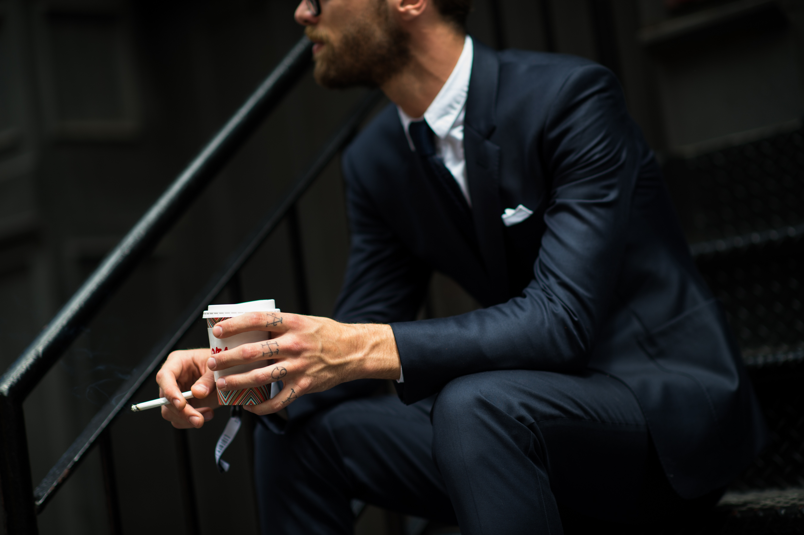 Man with tattooed hands in suit