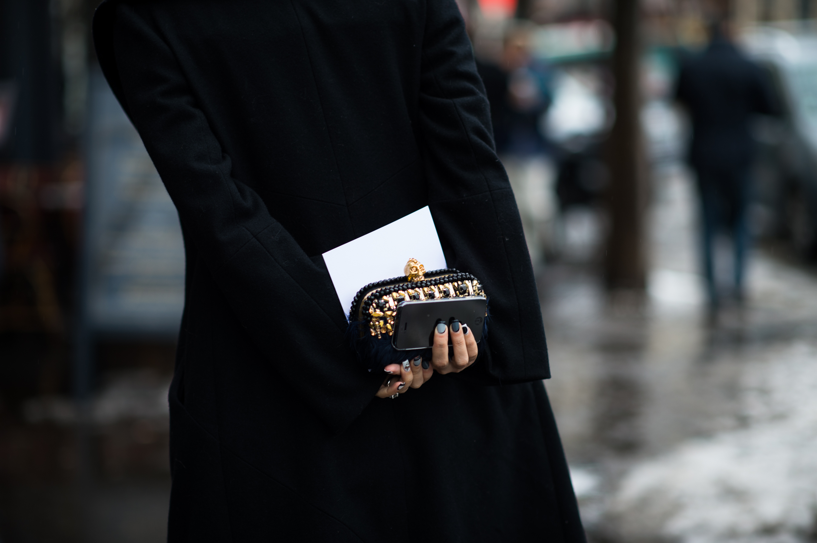 Woman with grey nails and McQueen clutch