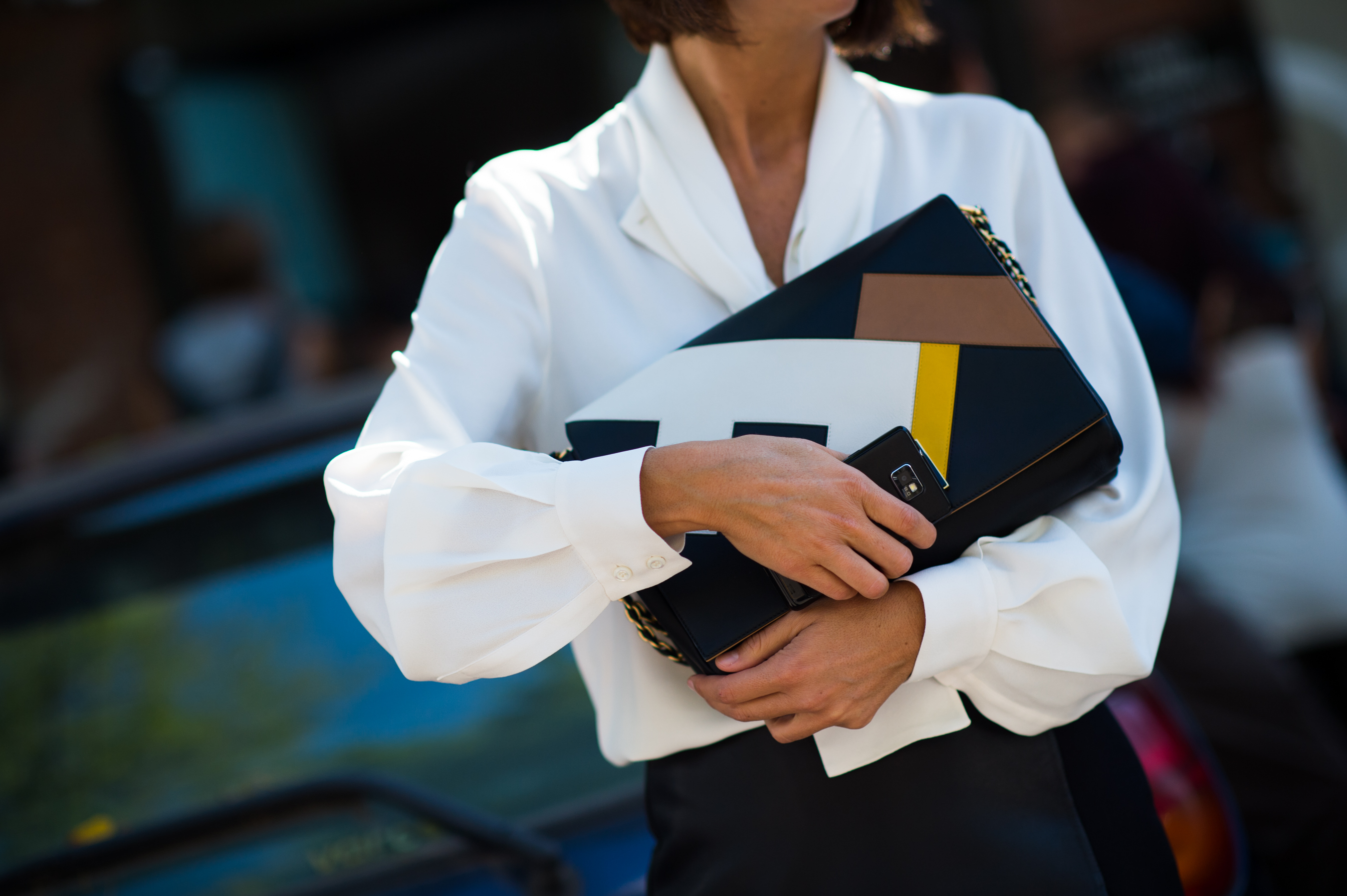 Woman holding Fendi clutch in arms