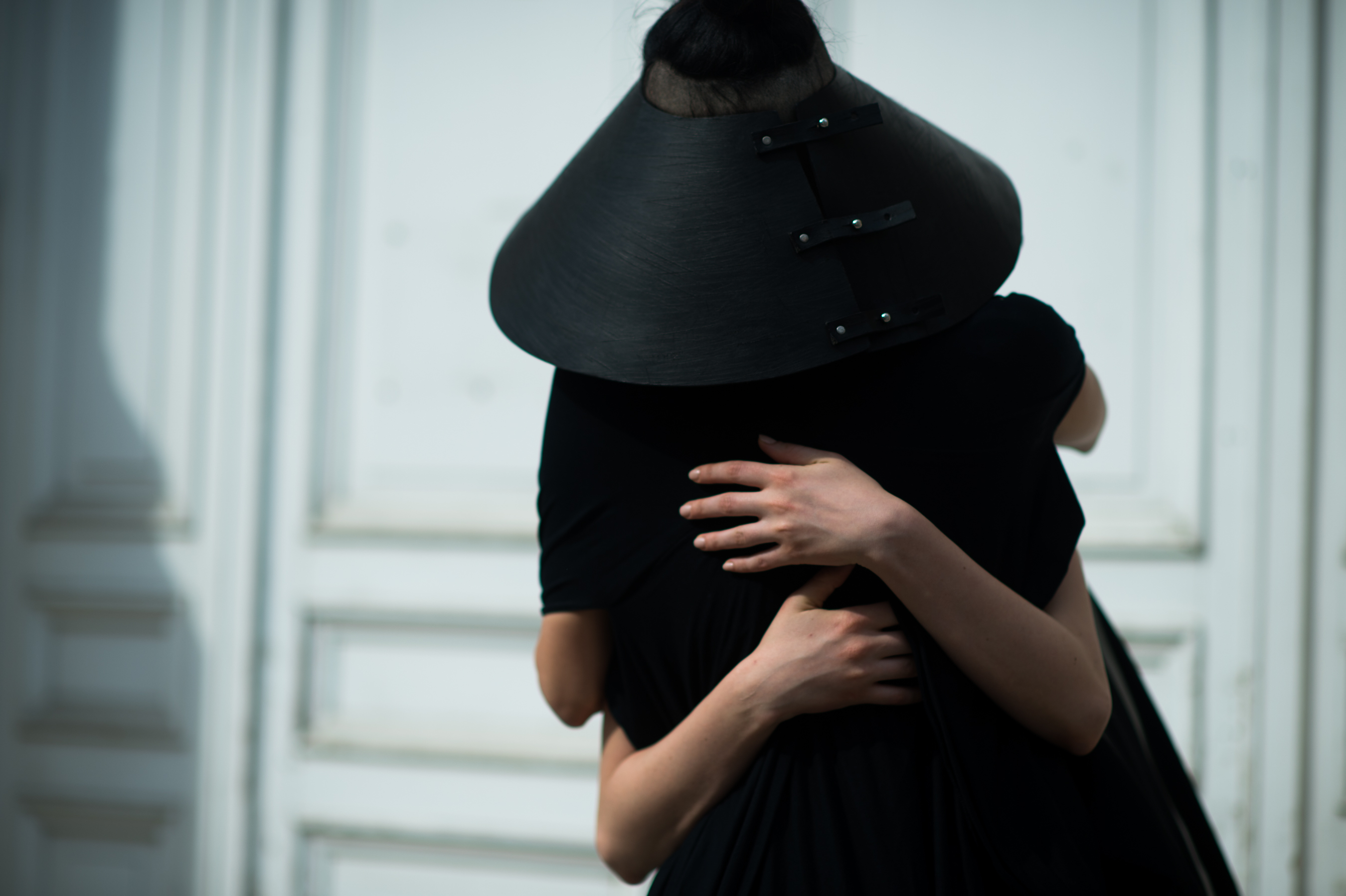 Woman wearing black leather hat hugging