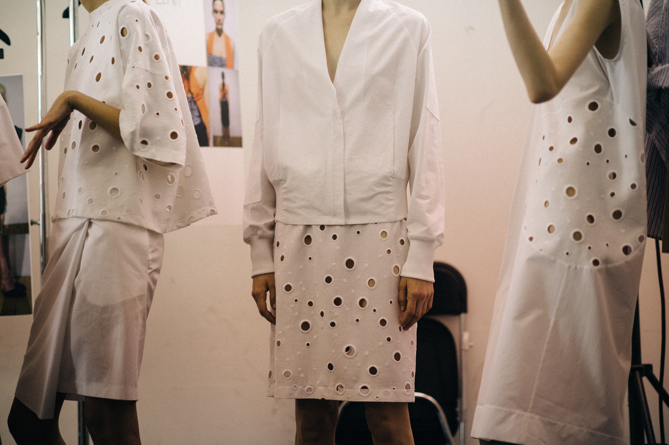 Three models wearing perforated dresses