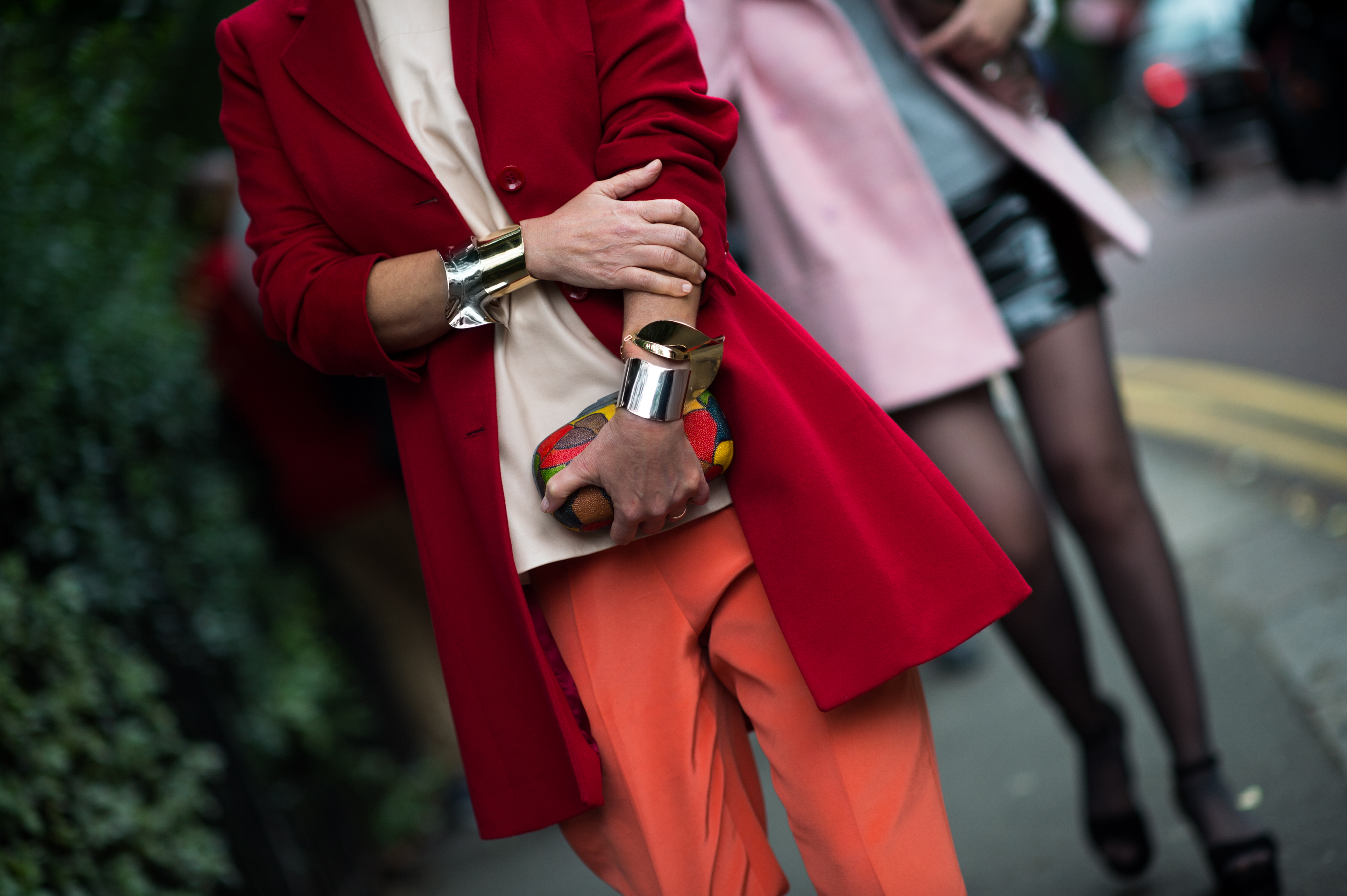Woman wearing red jacket and gold bracelets
