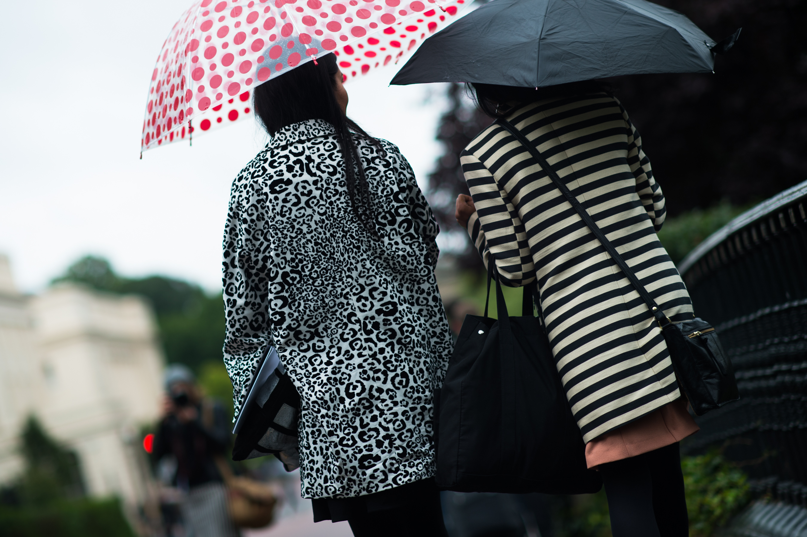 Two women walking with umbrellas