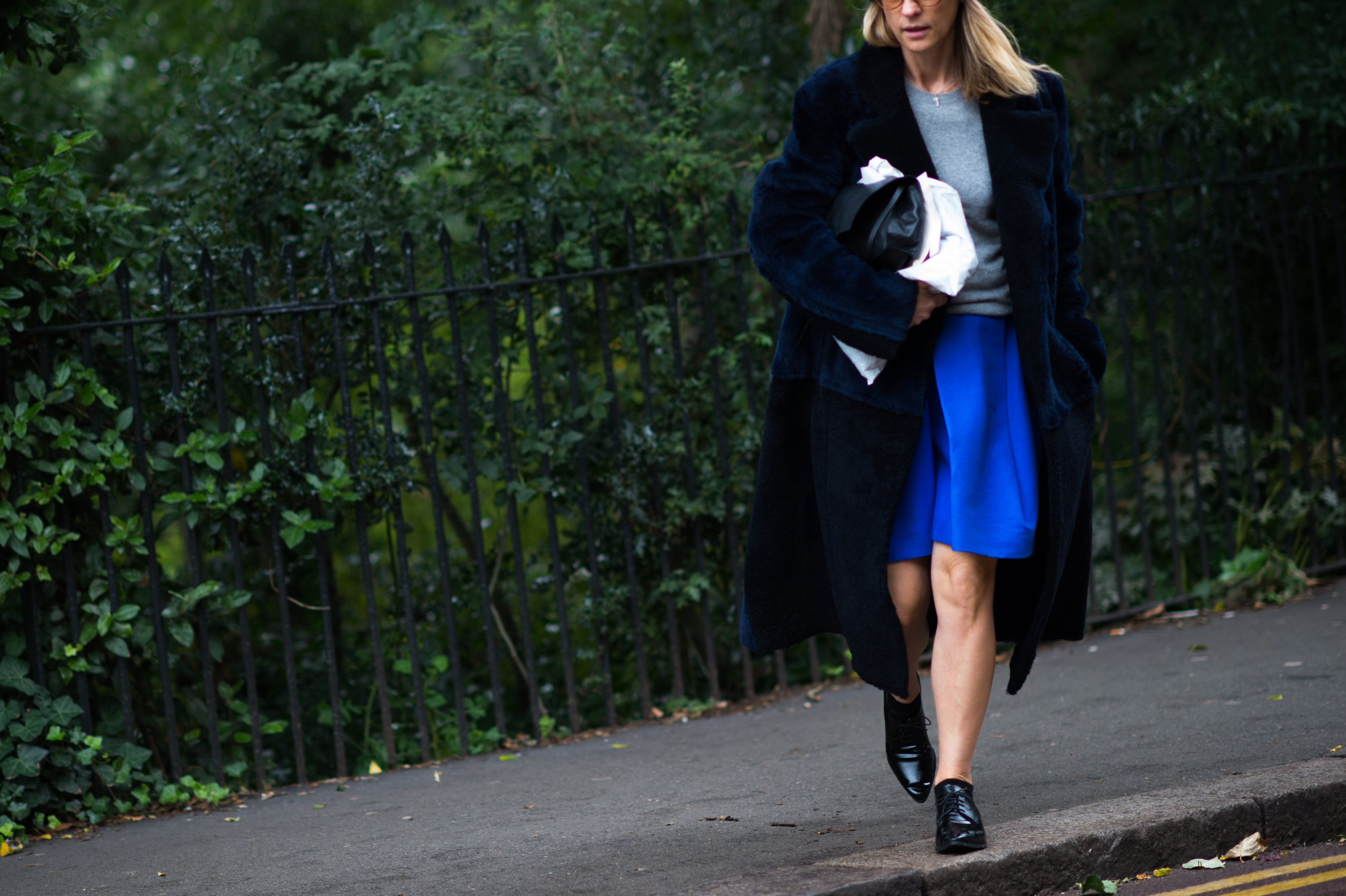 Woman wearing blue skirt and big coat