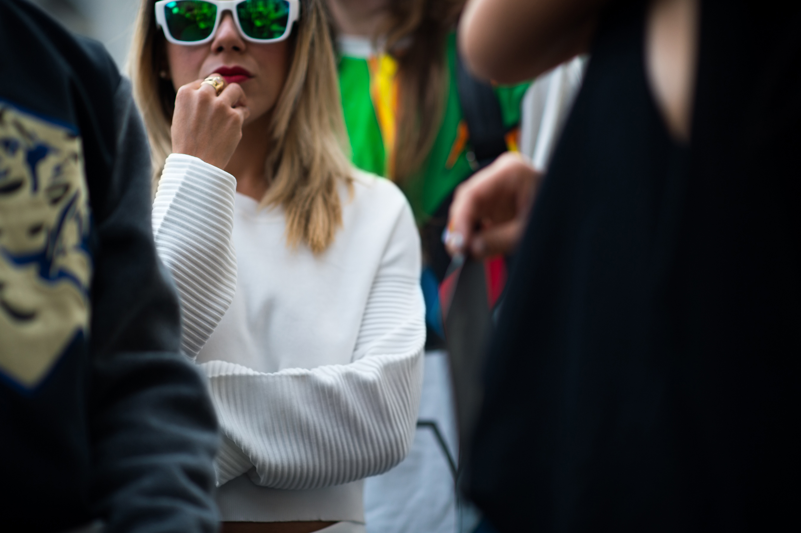 Girl wearing white top and green sunglasses