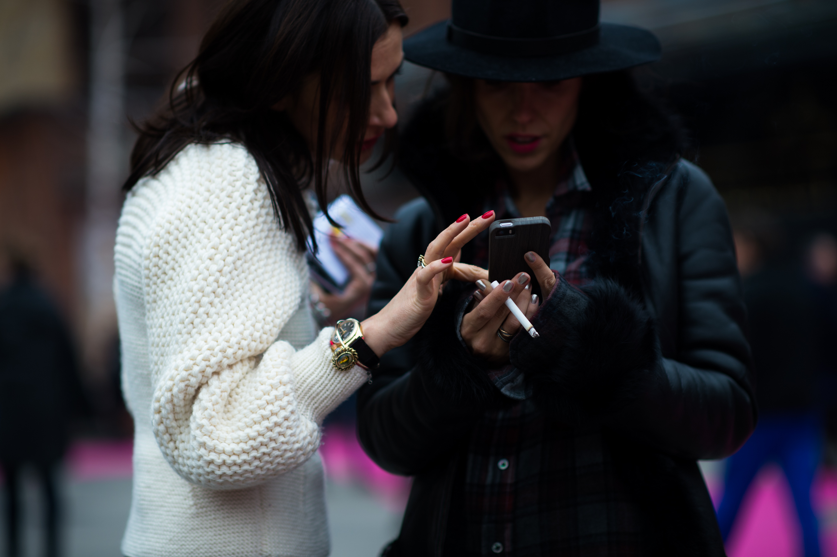 Two women texting at Premium