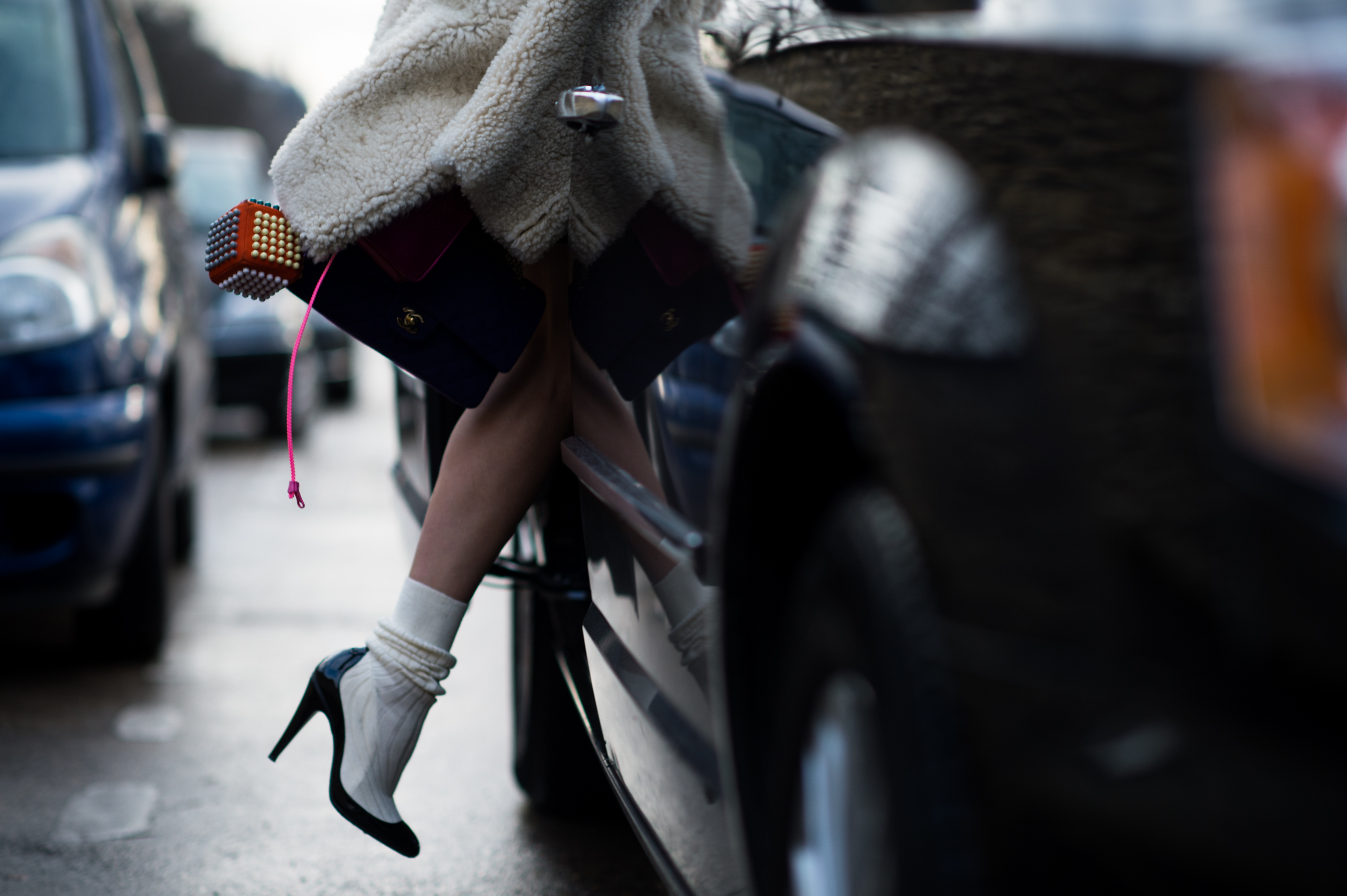 Woman with two Chanel bags getting into a car