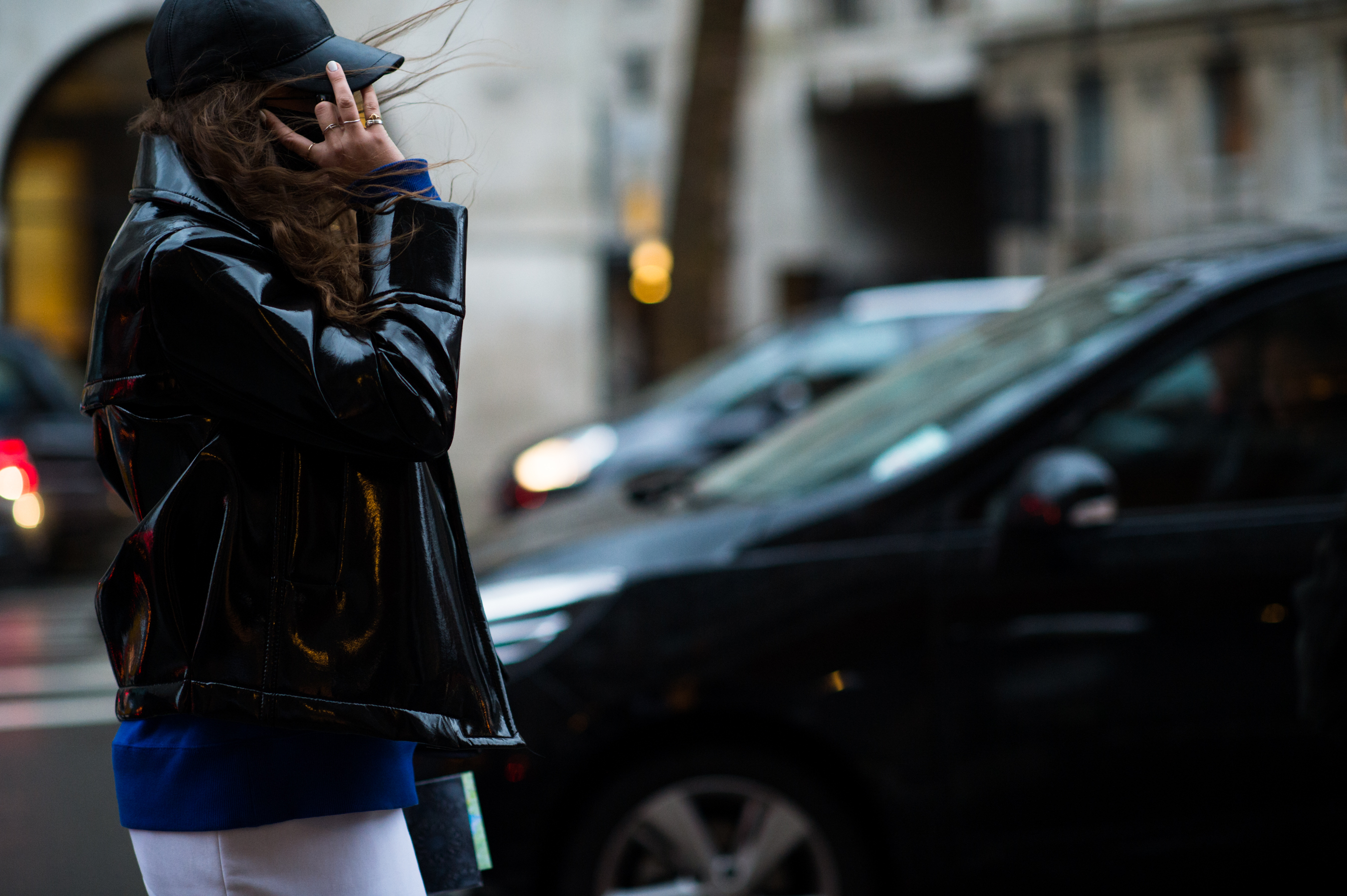 Woman in patent leather jacket on her phone