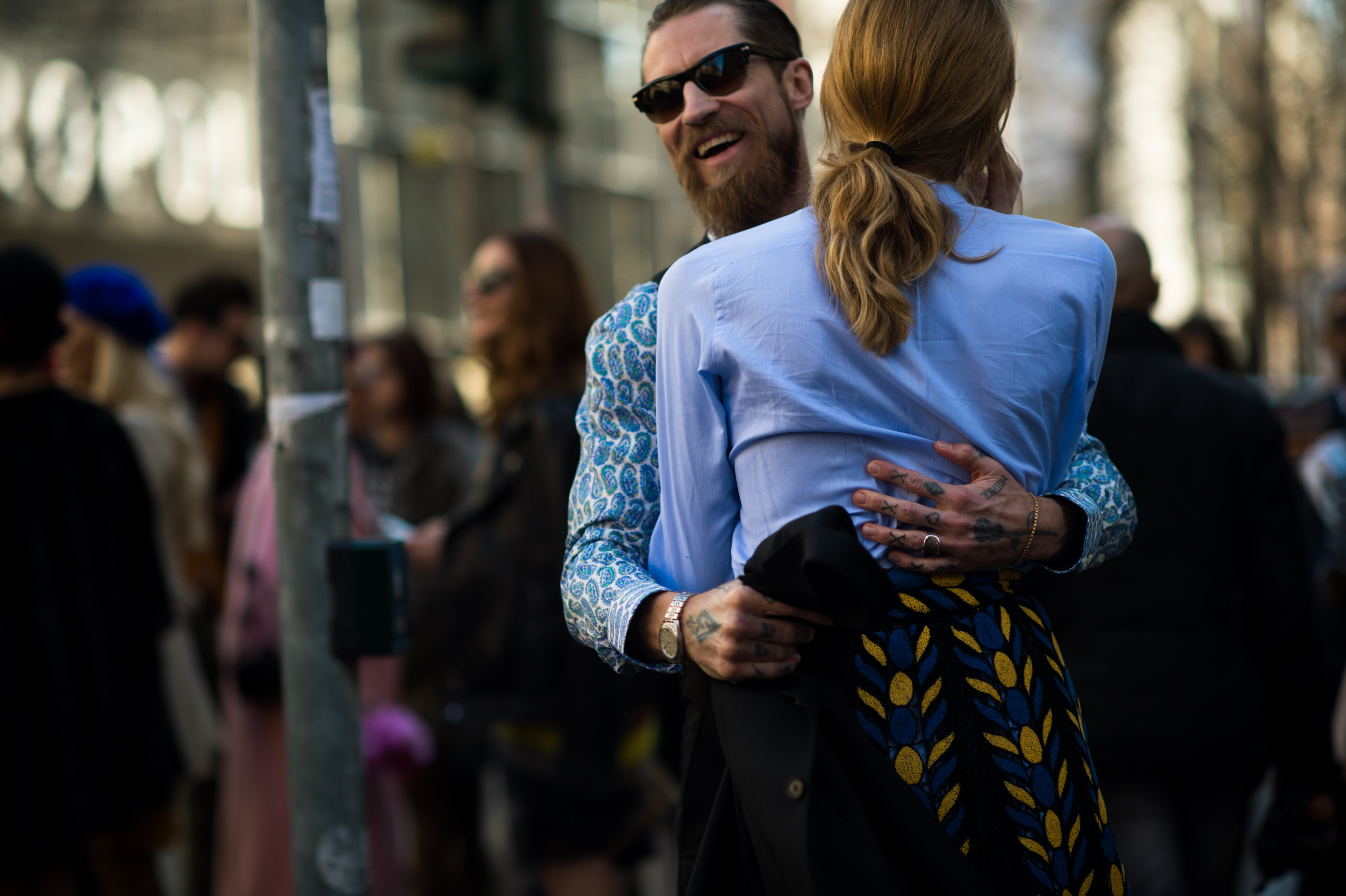 Man with tattooed hands hugging girl
