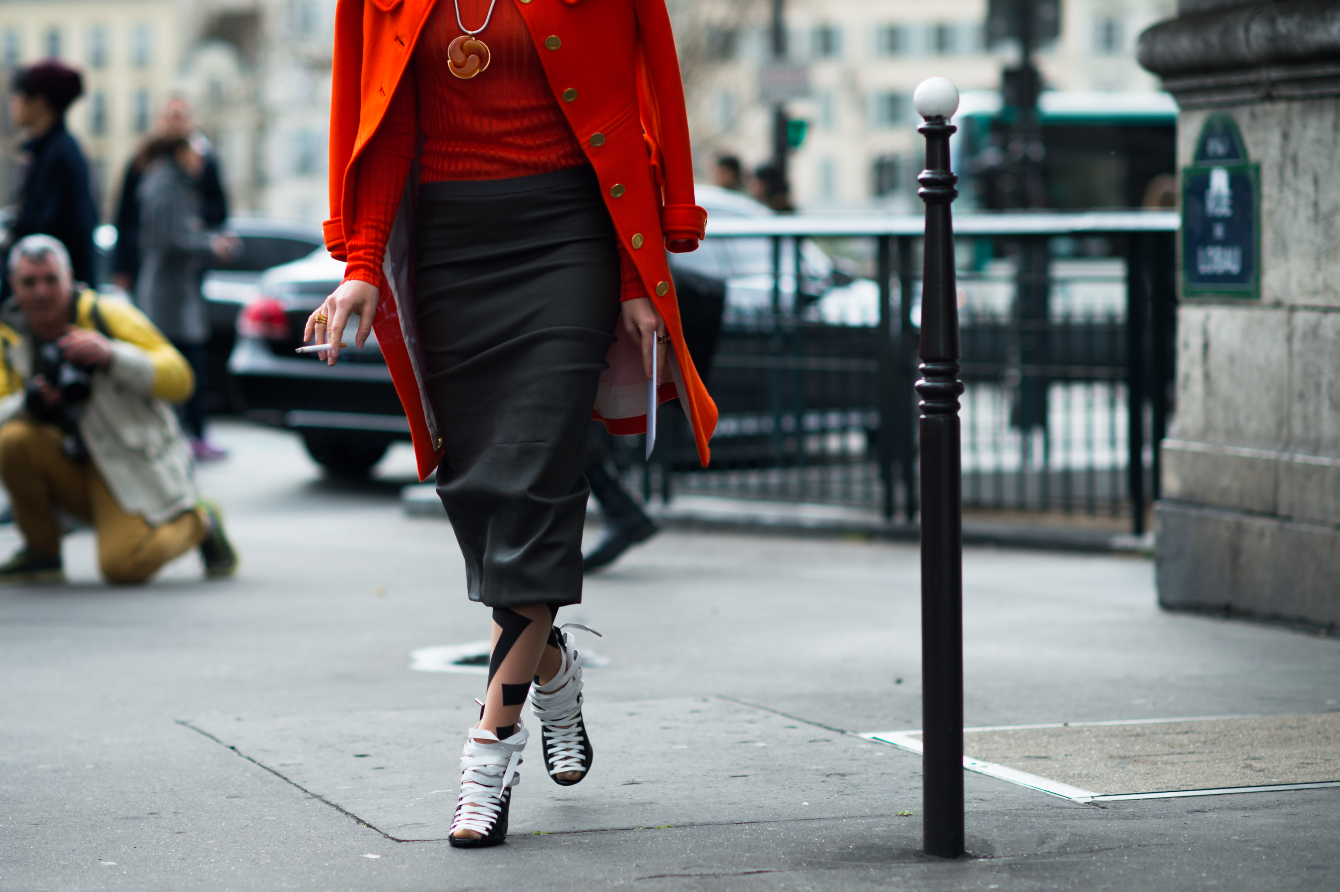 Woman wearing red coat with Balenciaga shoes