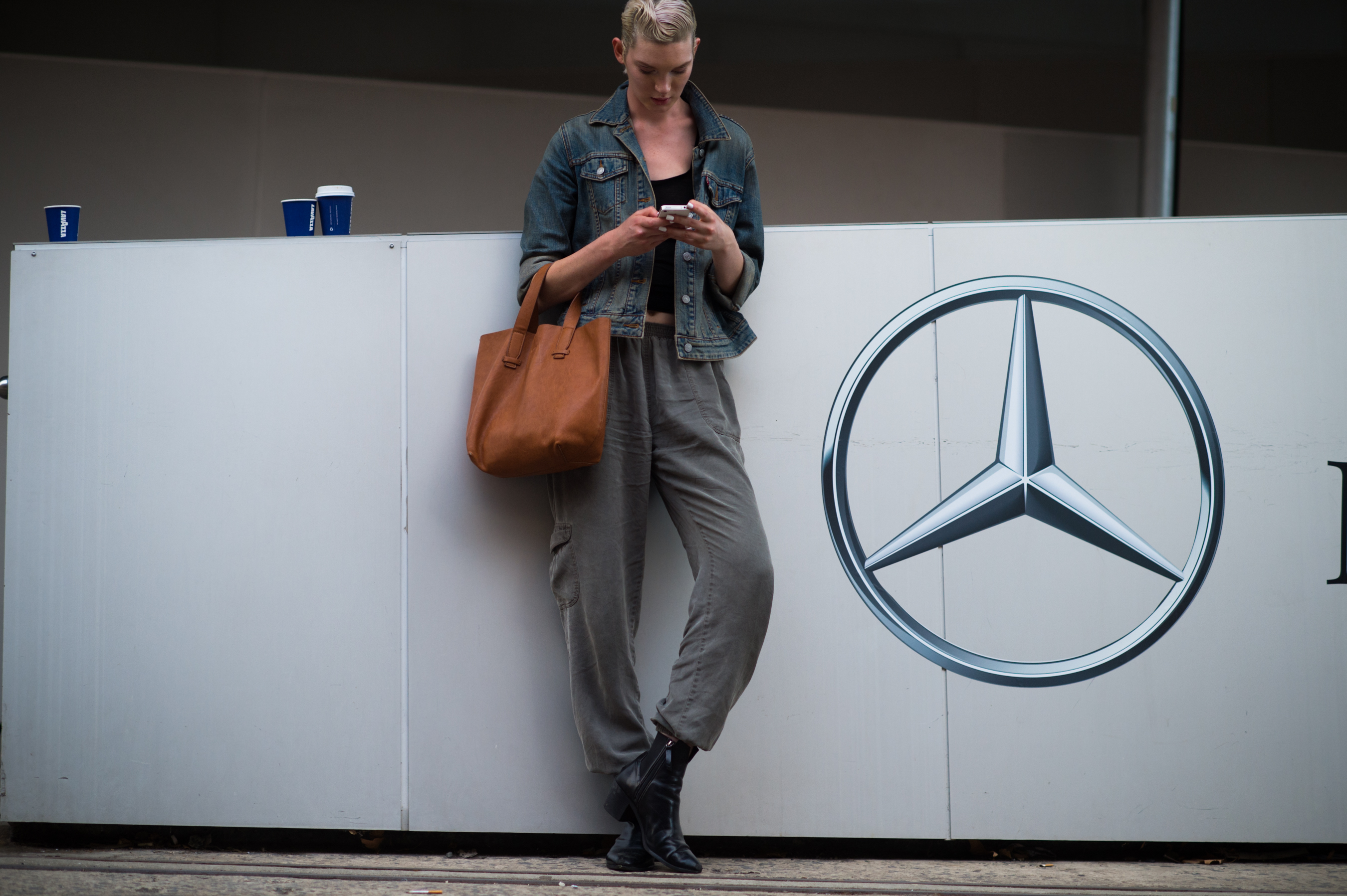 Model leaning against Mercedes-Benz logo