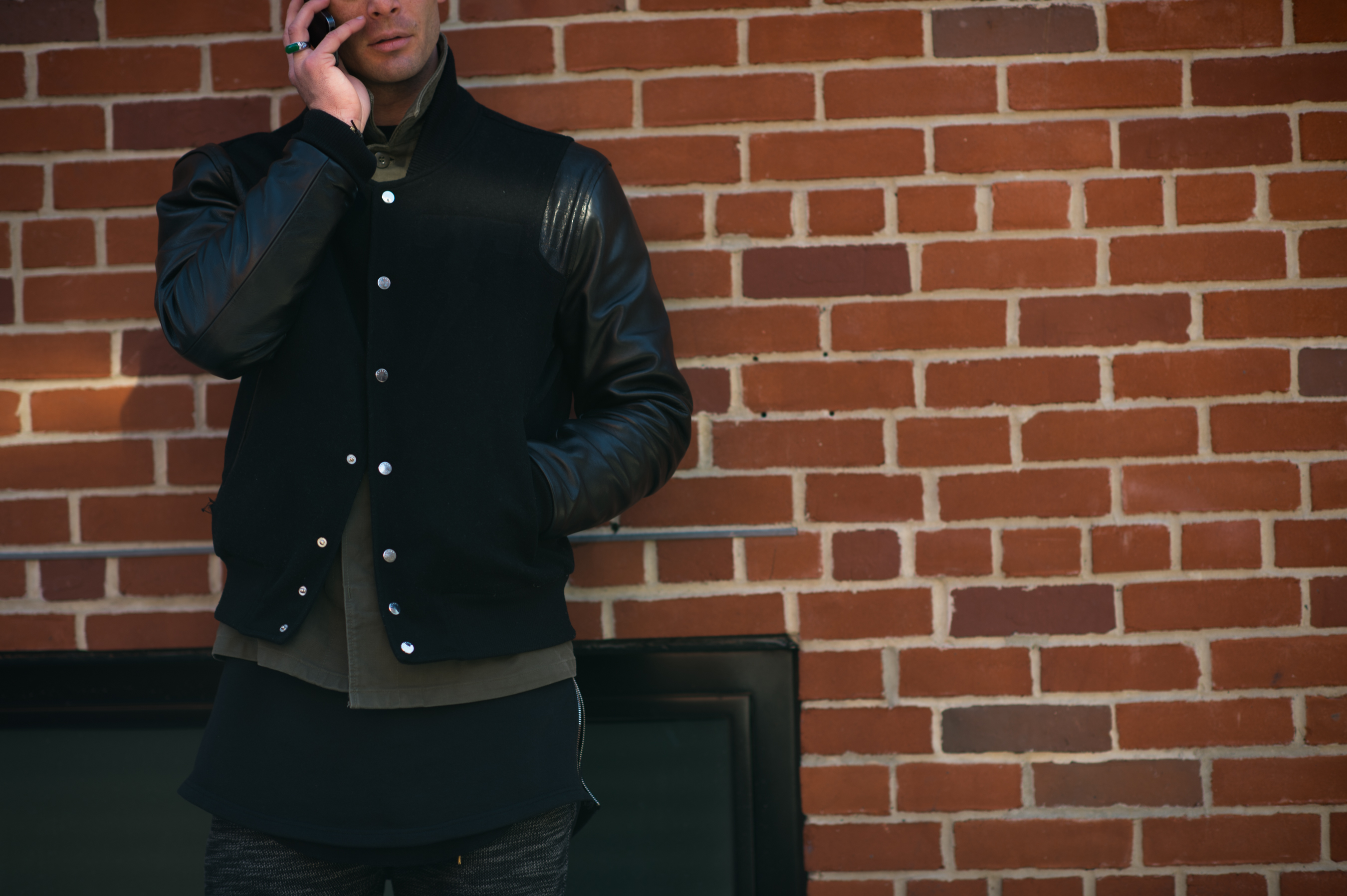 Man wearing a black varsity jacket