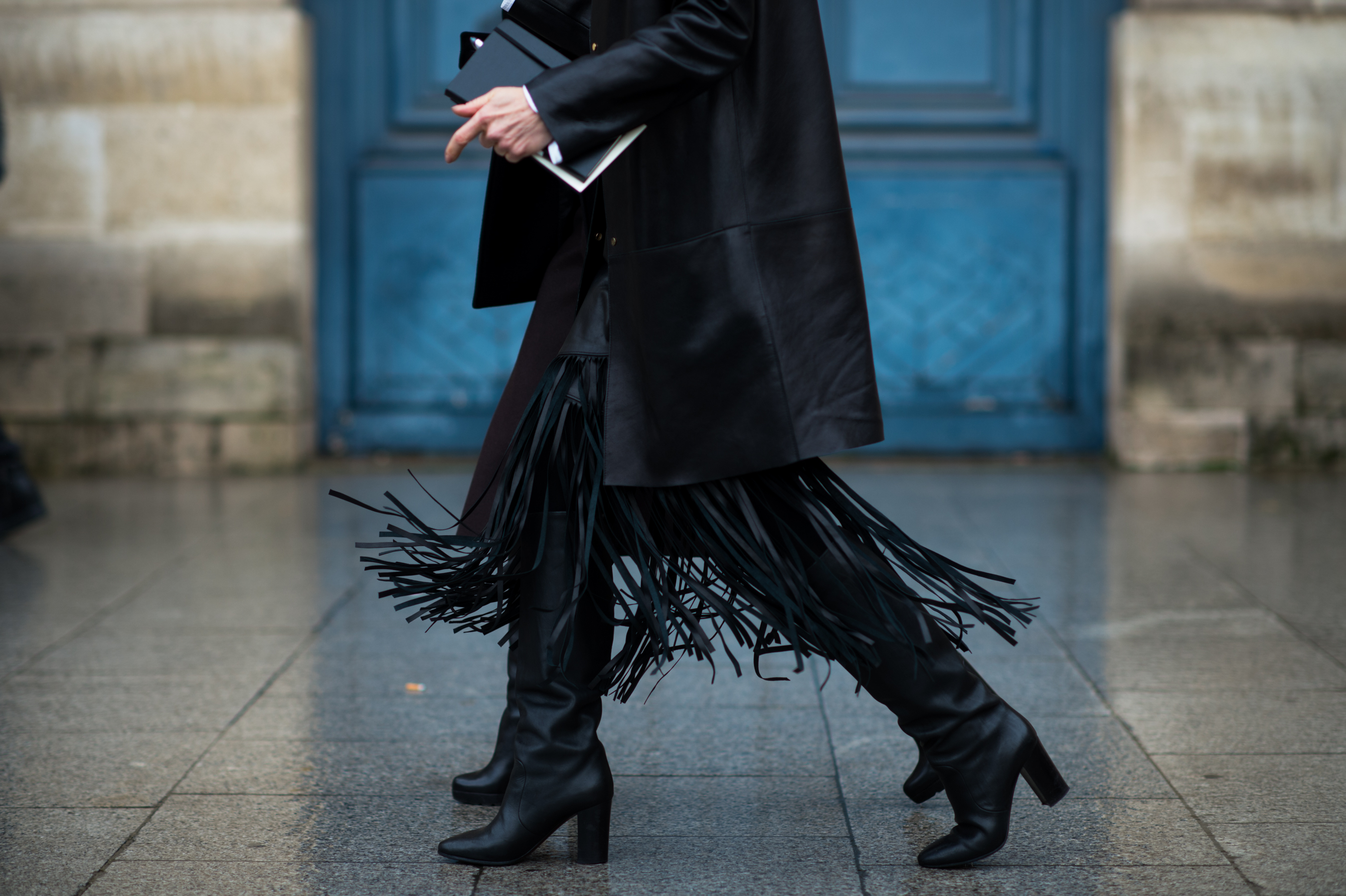 Woman wearing black leather fringe dress