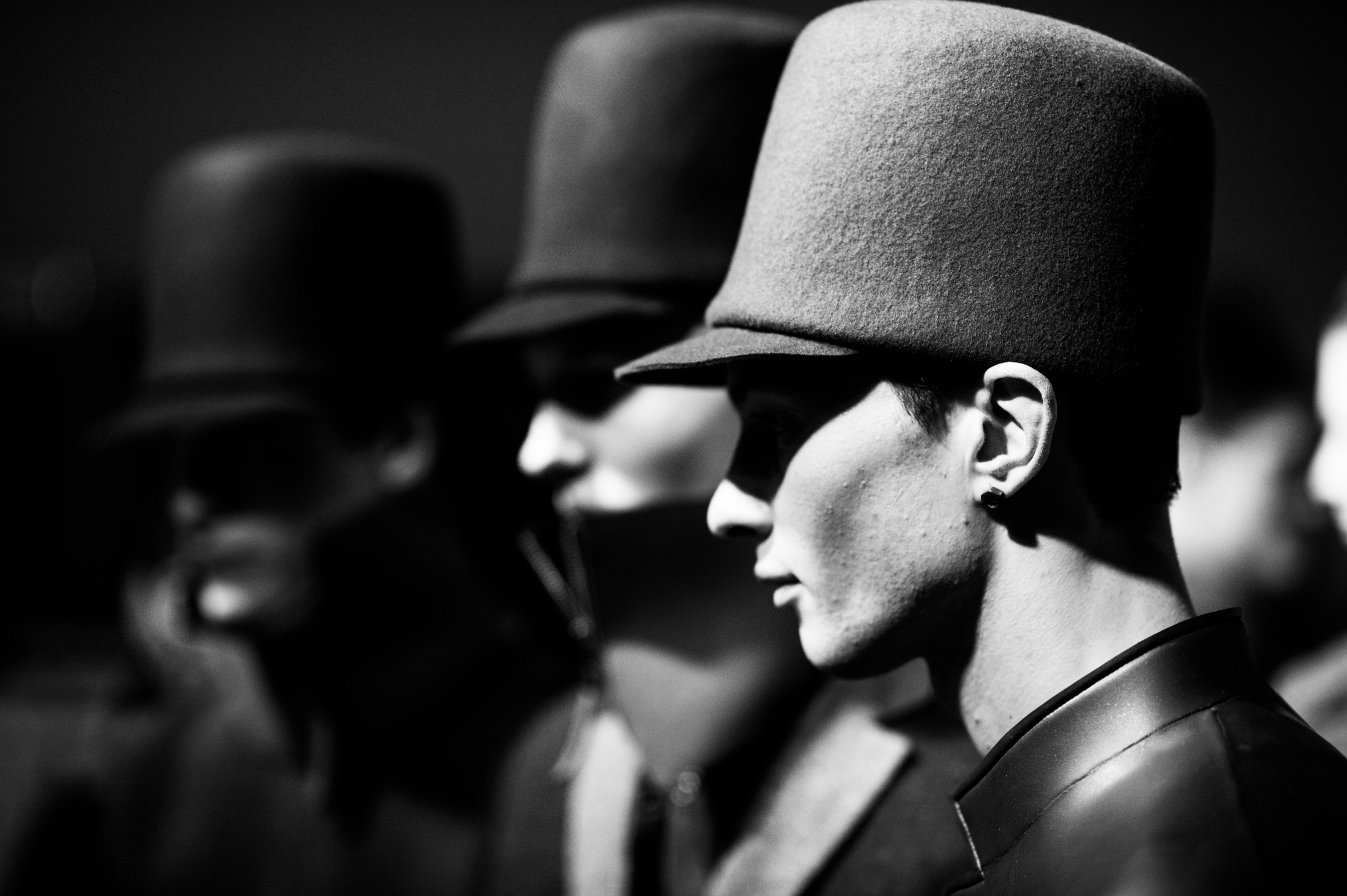 Three male models with tall hats