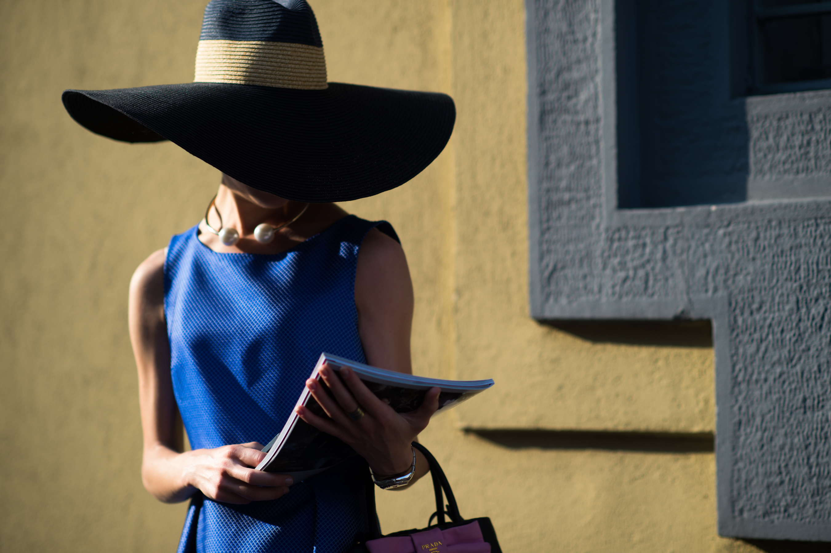 Girl wearing a blue dress and big black hat