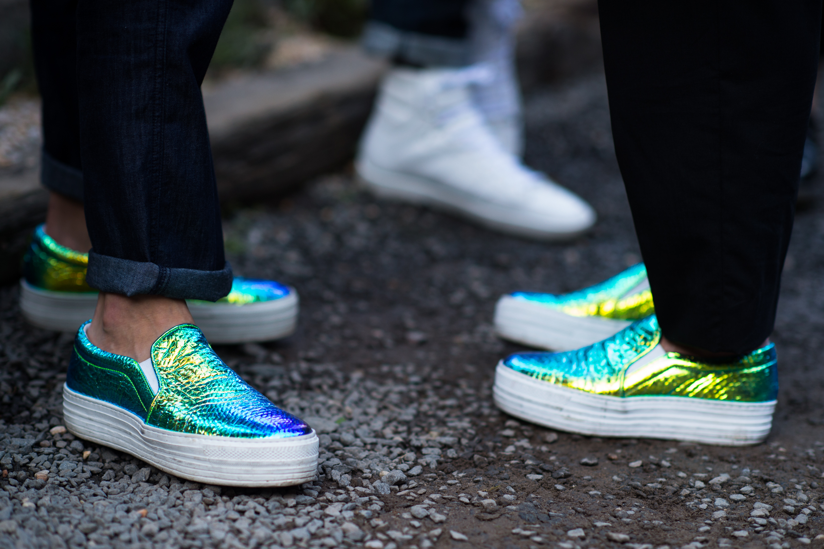 Two women wearing matching metallic sneakers