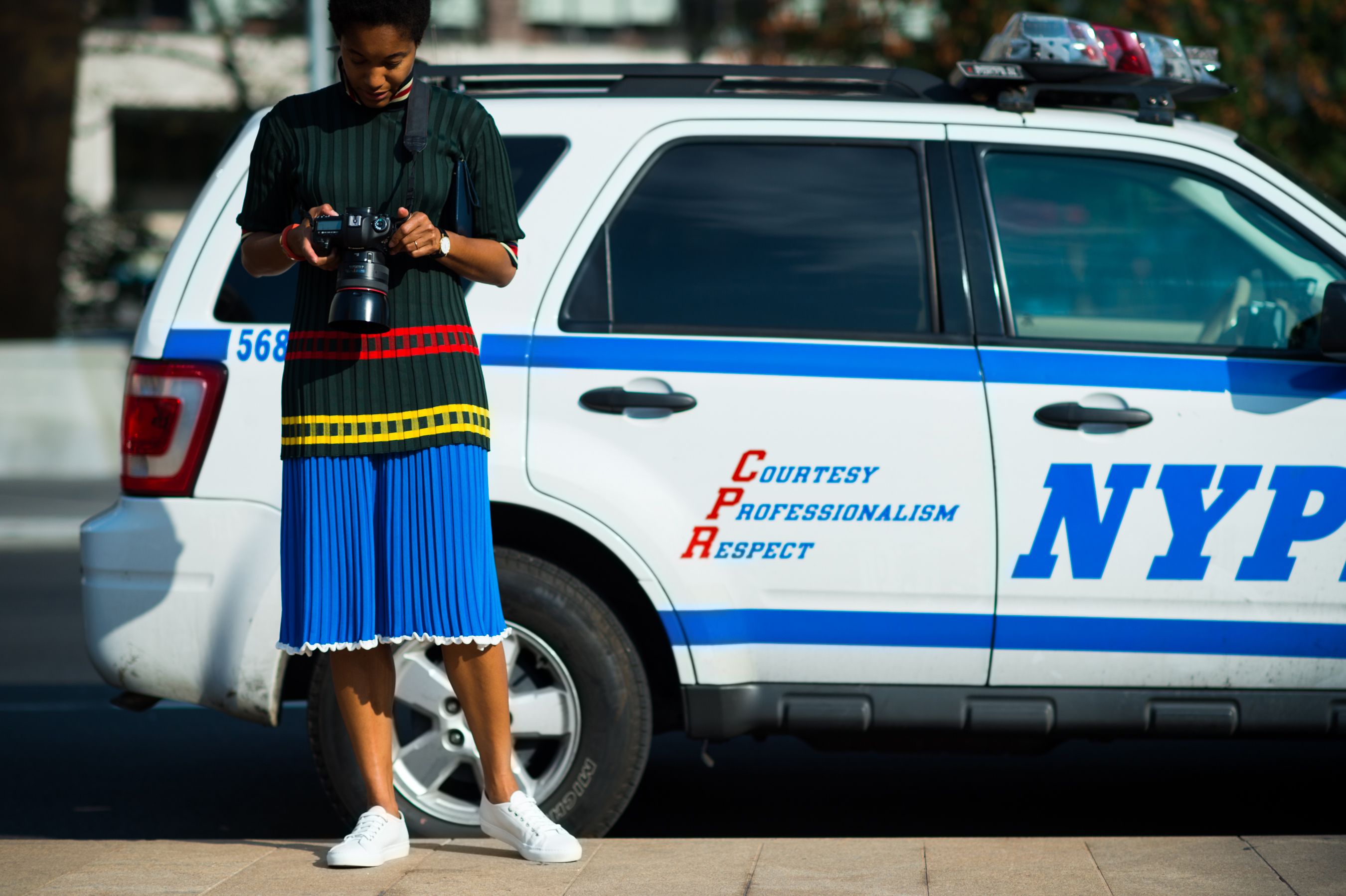 Woman next to an NYPD car