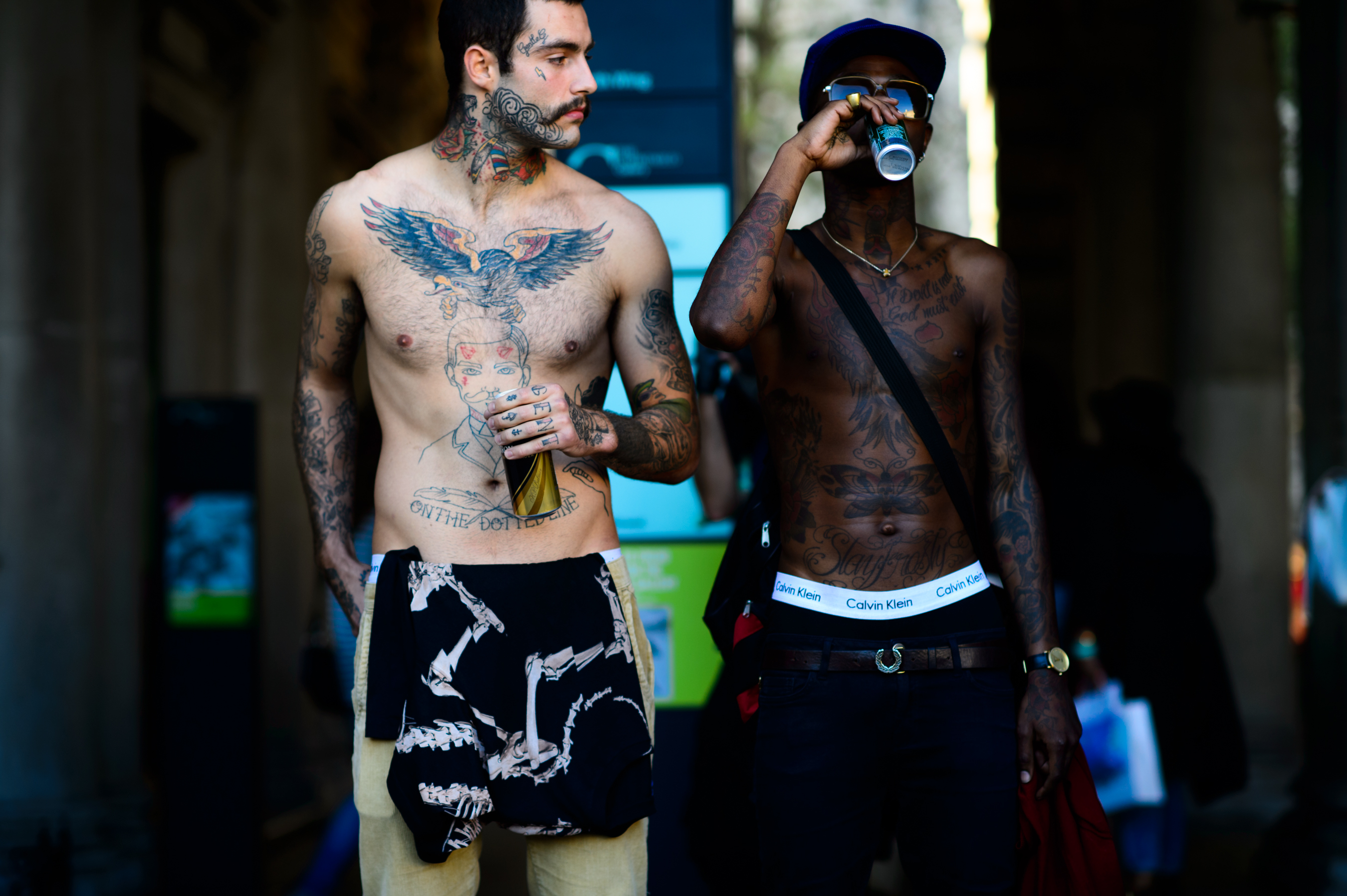Two men drinking beer with tattoos