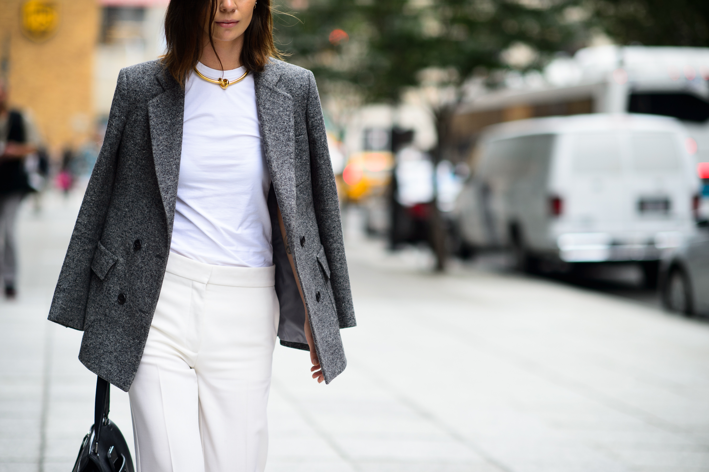 Woman wearing a grey jacket and leather slides