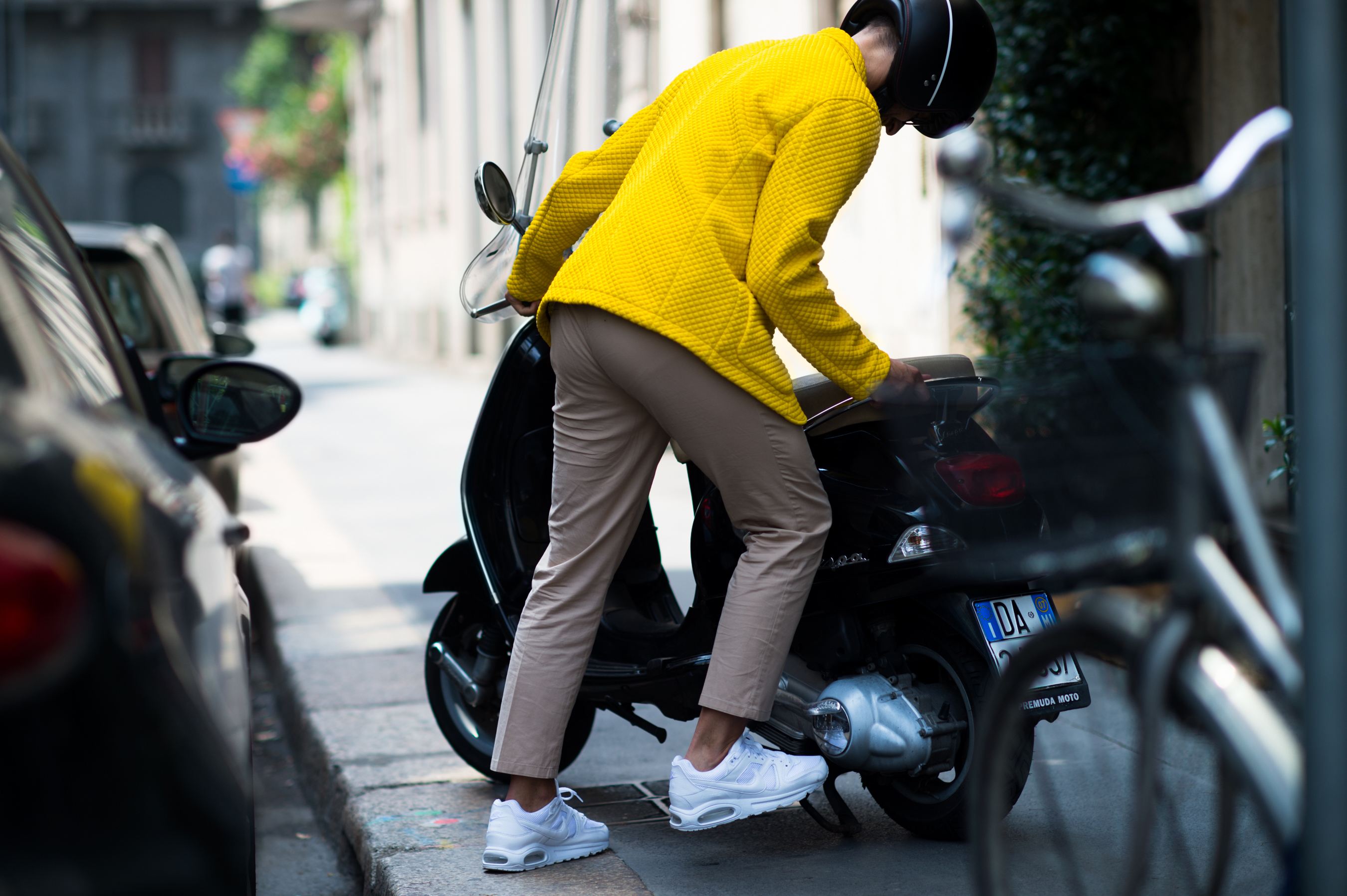 Italian journalist wearing a yellow jacket on his Vespa