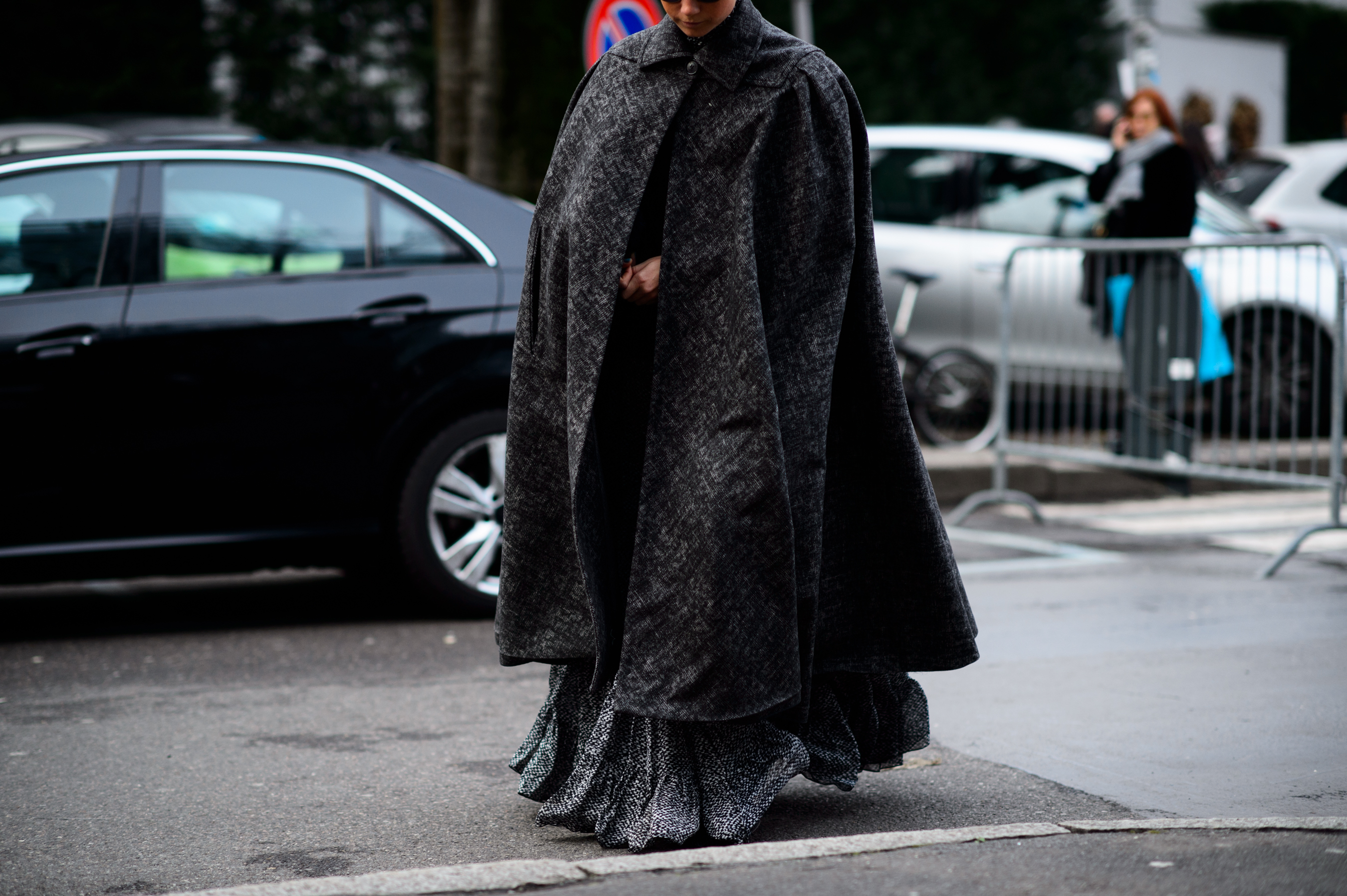 Woman wearing a massive grey cape
