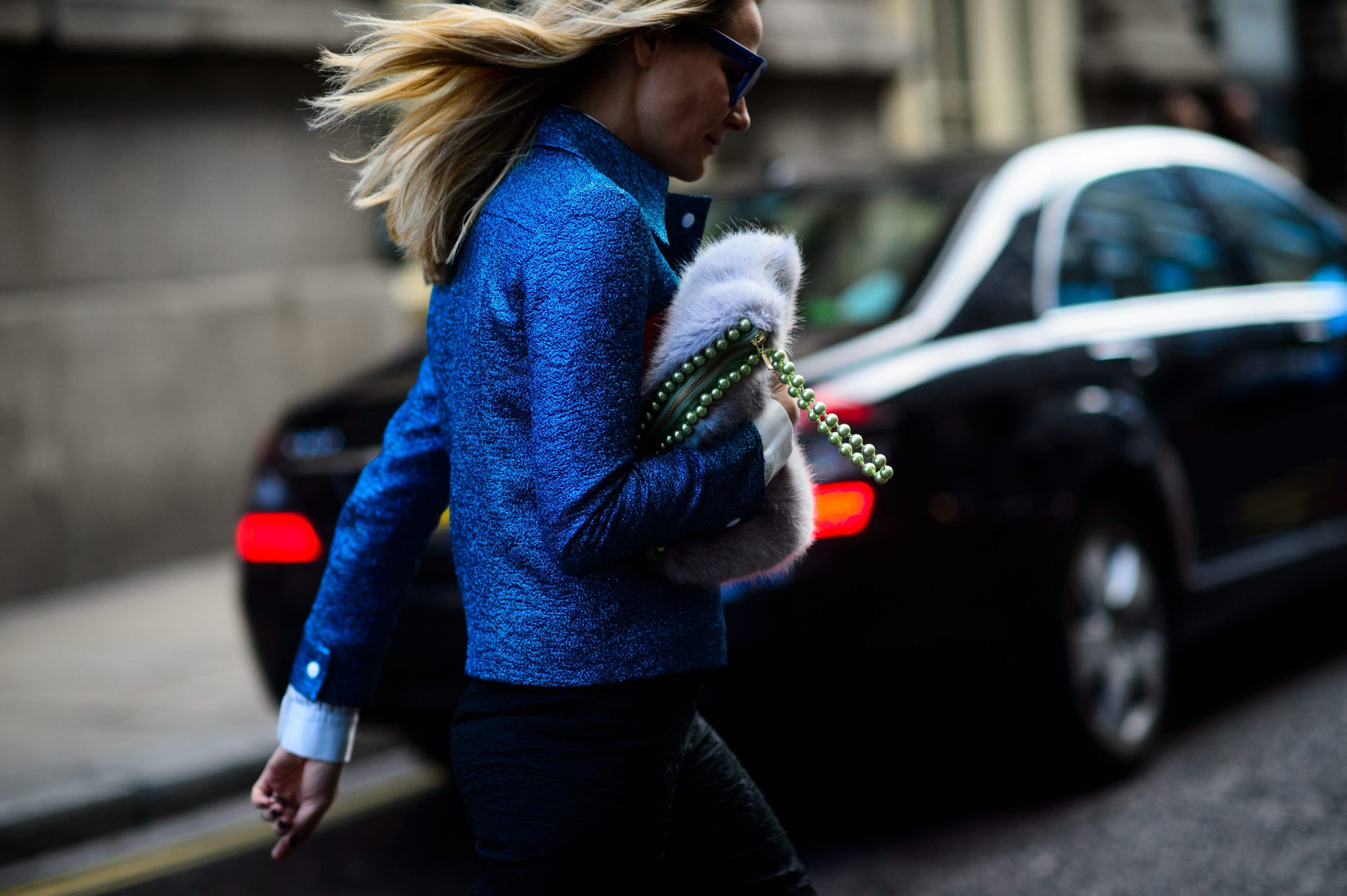 Woman wearing a blue jacket running to a show