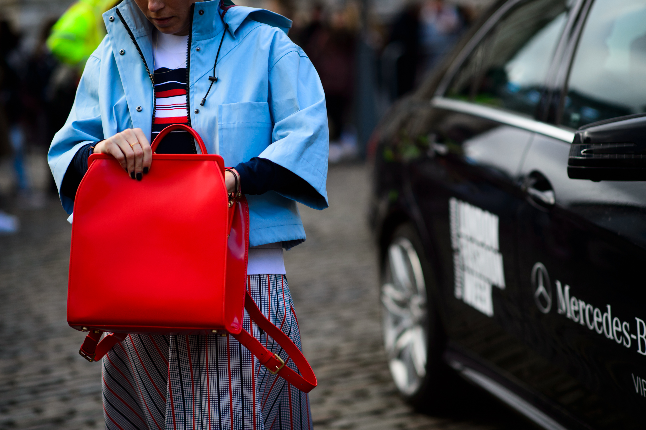 Woman in a blue jacket with a red backpack