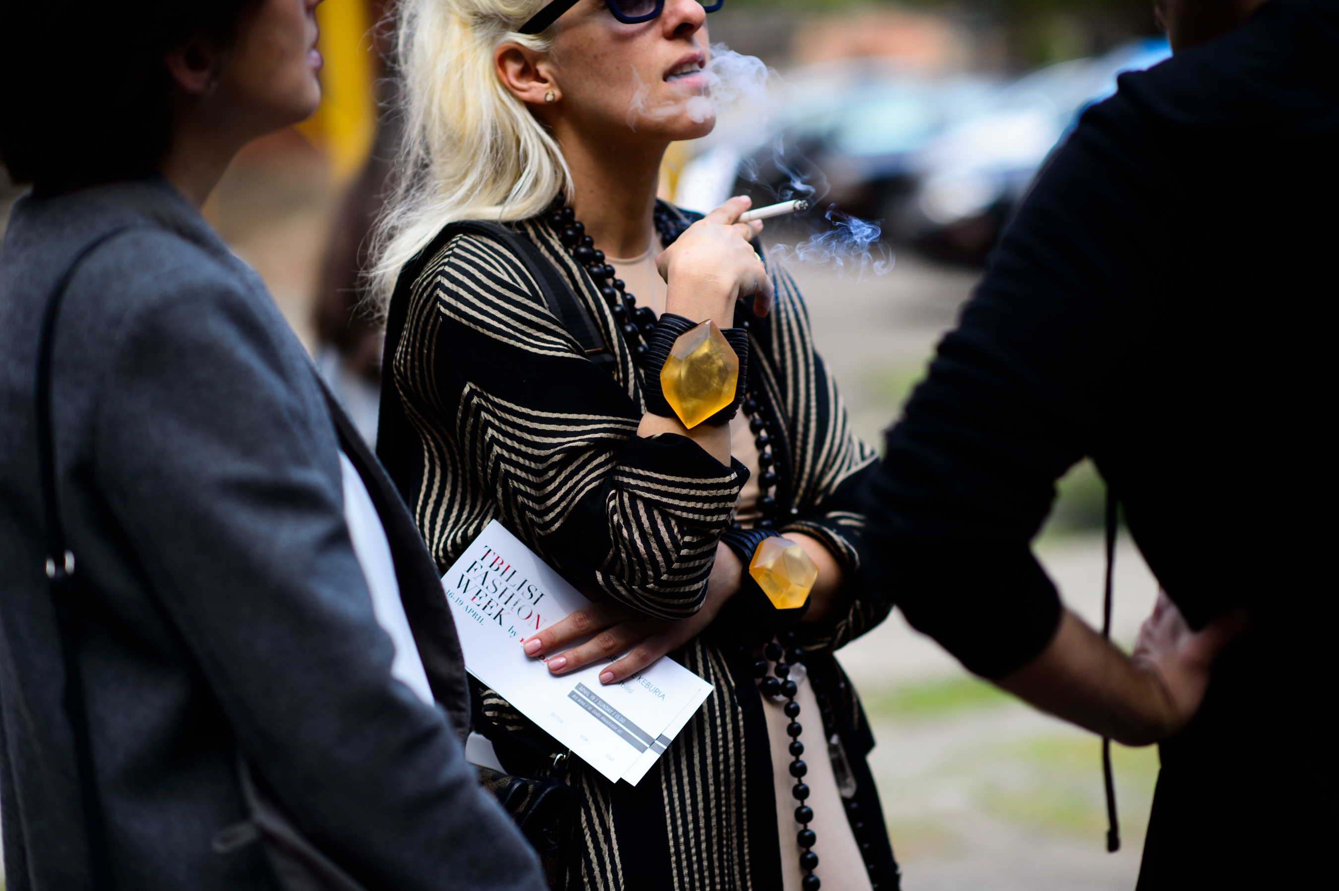 Woman smoking wearing big bracelets