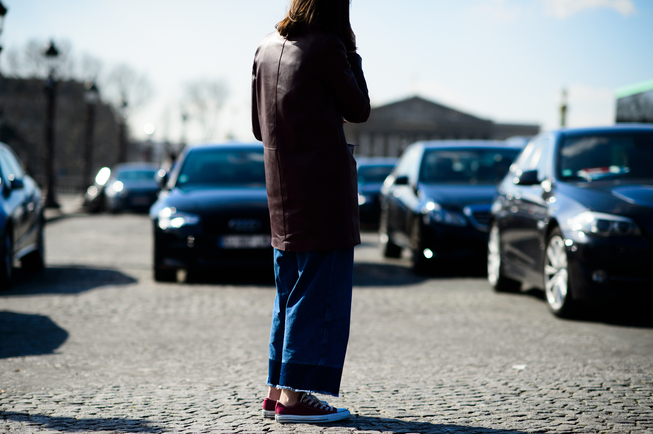Woman wearing an oxblood jacket and denim jeans