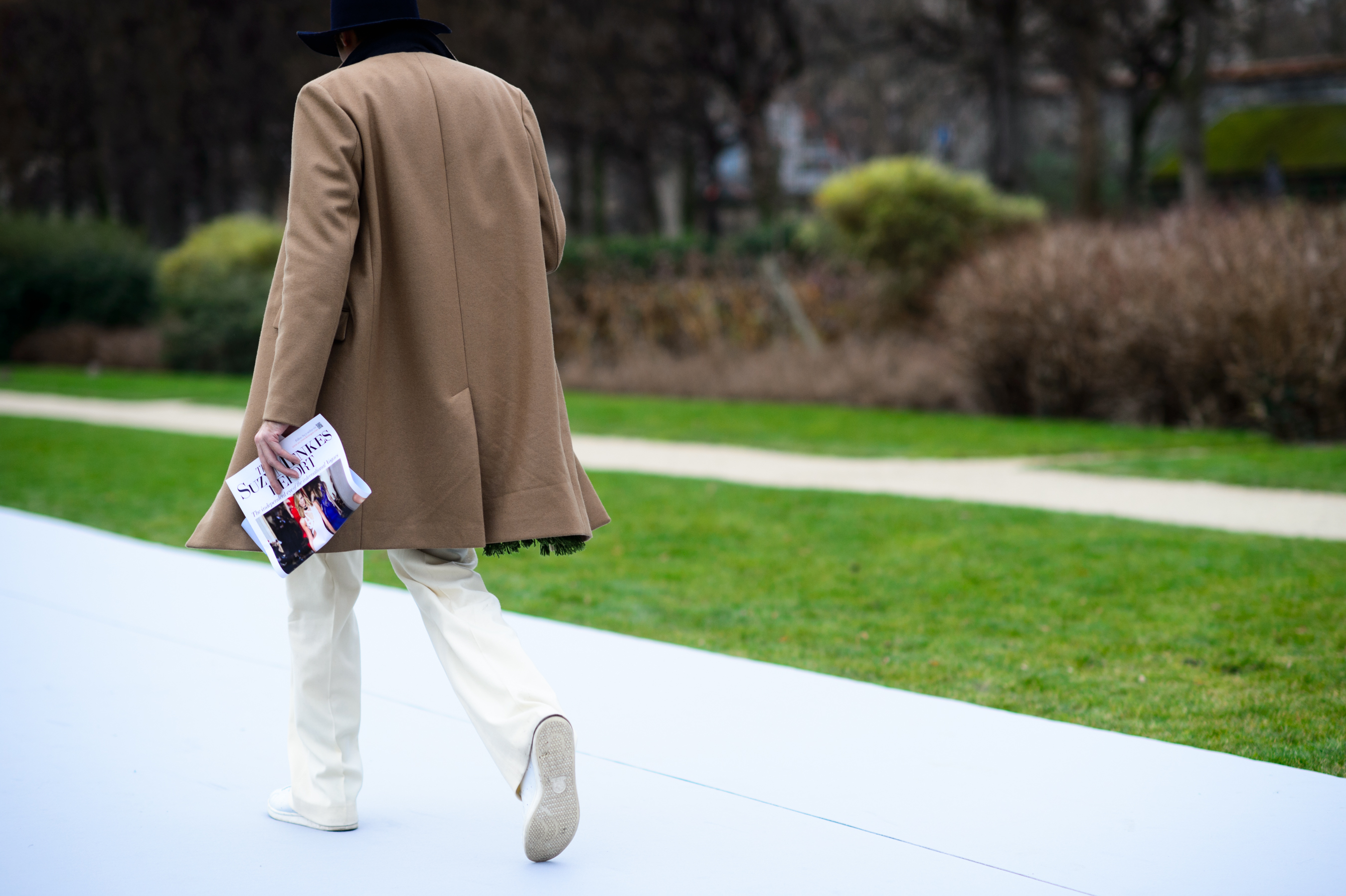 Man wearing a camel coat and white pants