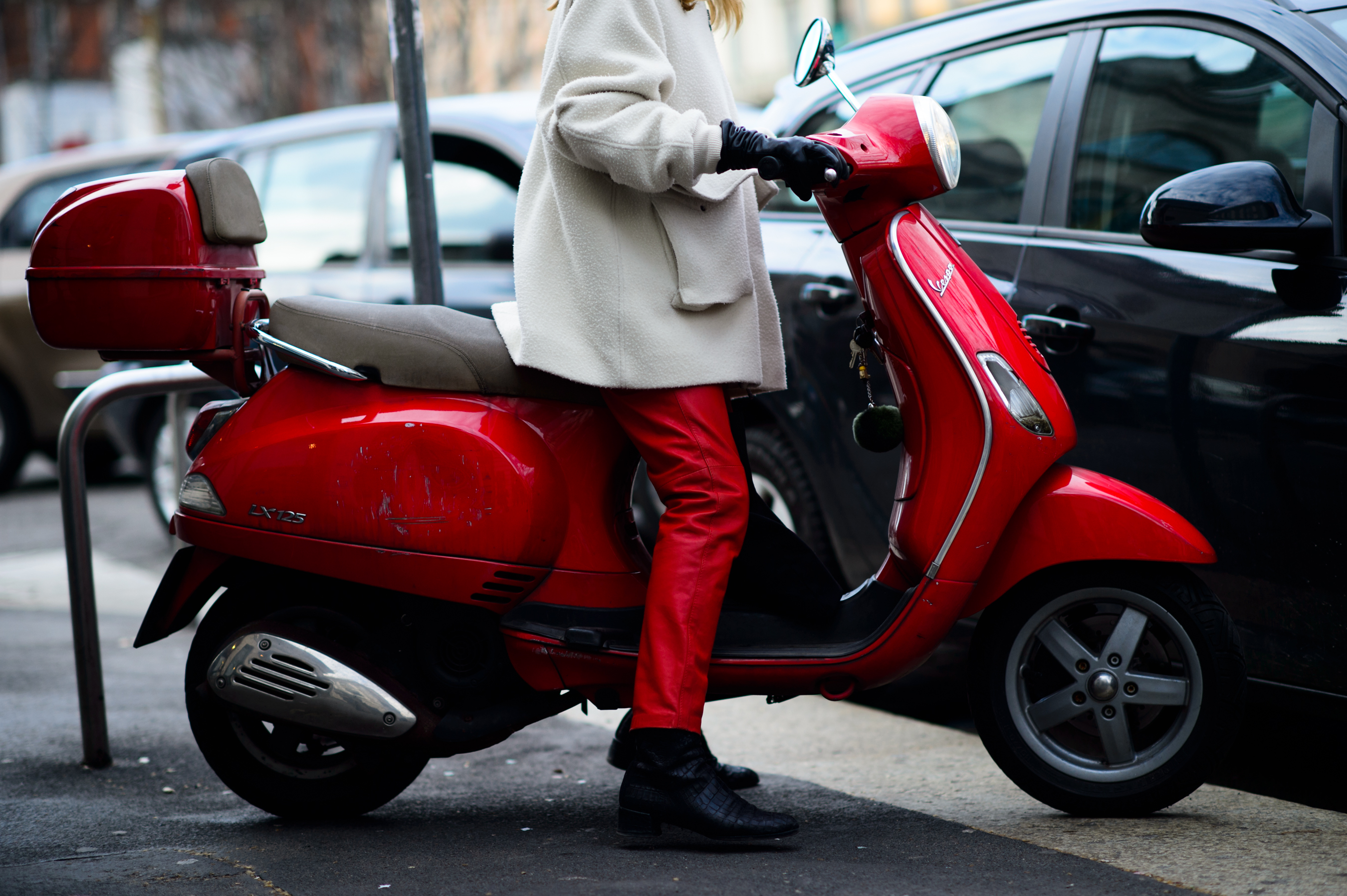 Woman on a red Vespa in red leather pants