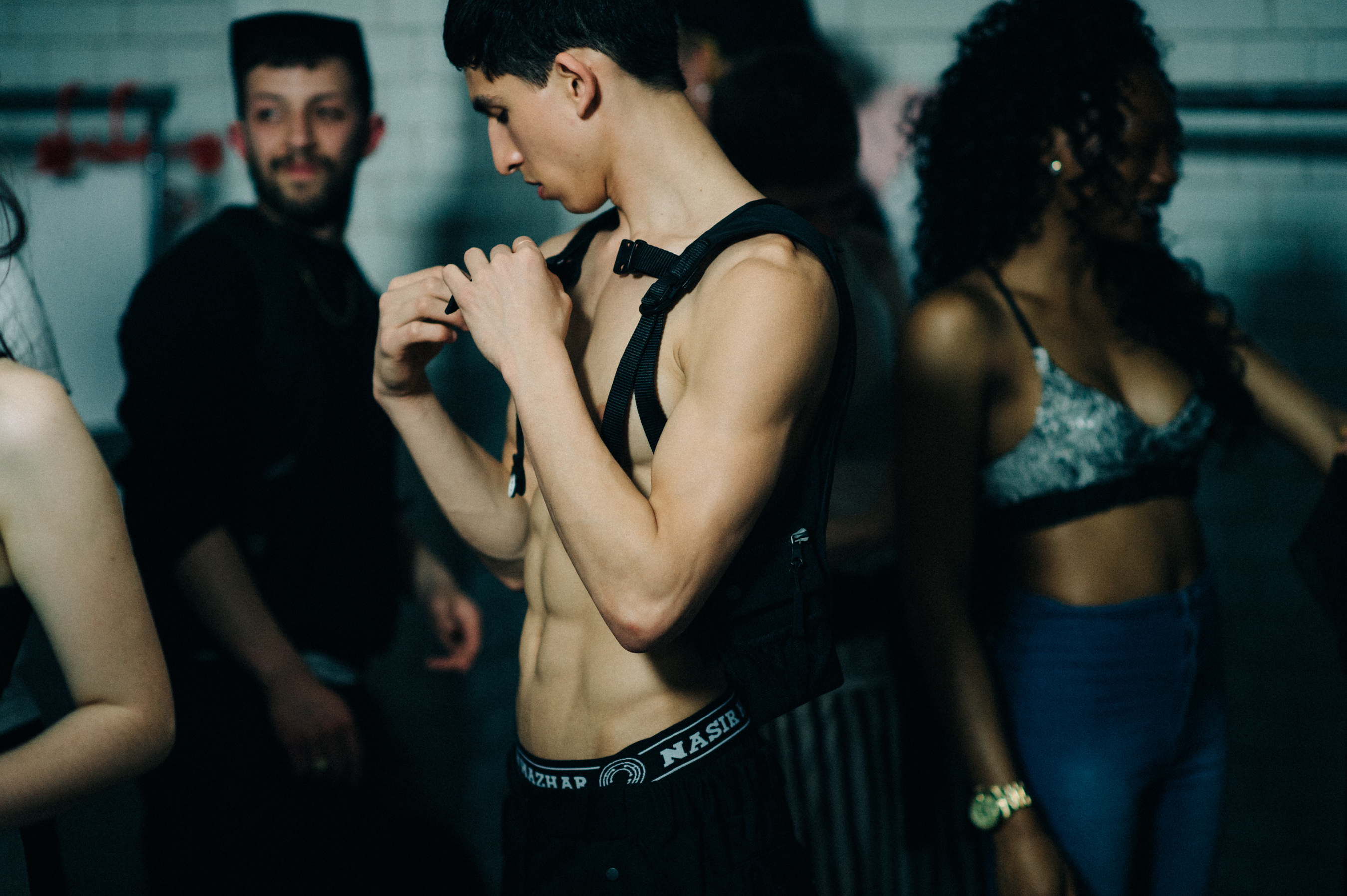 Male model is fixing his outfit before the show