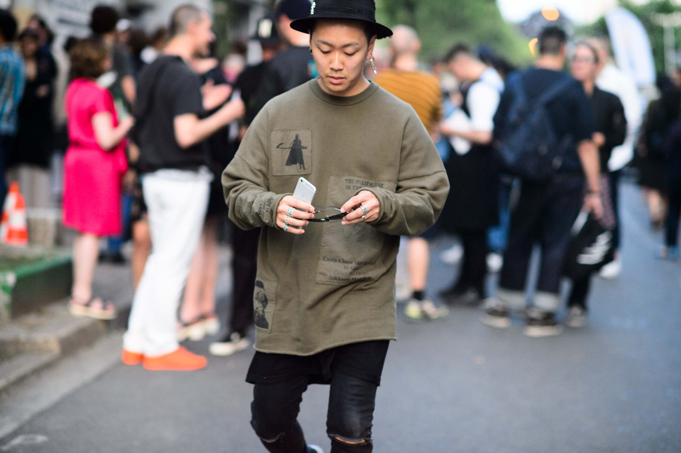 The man in a hat, sweatshirt and earring before the fashion show