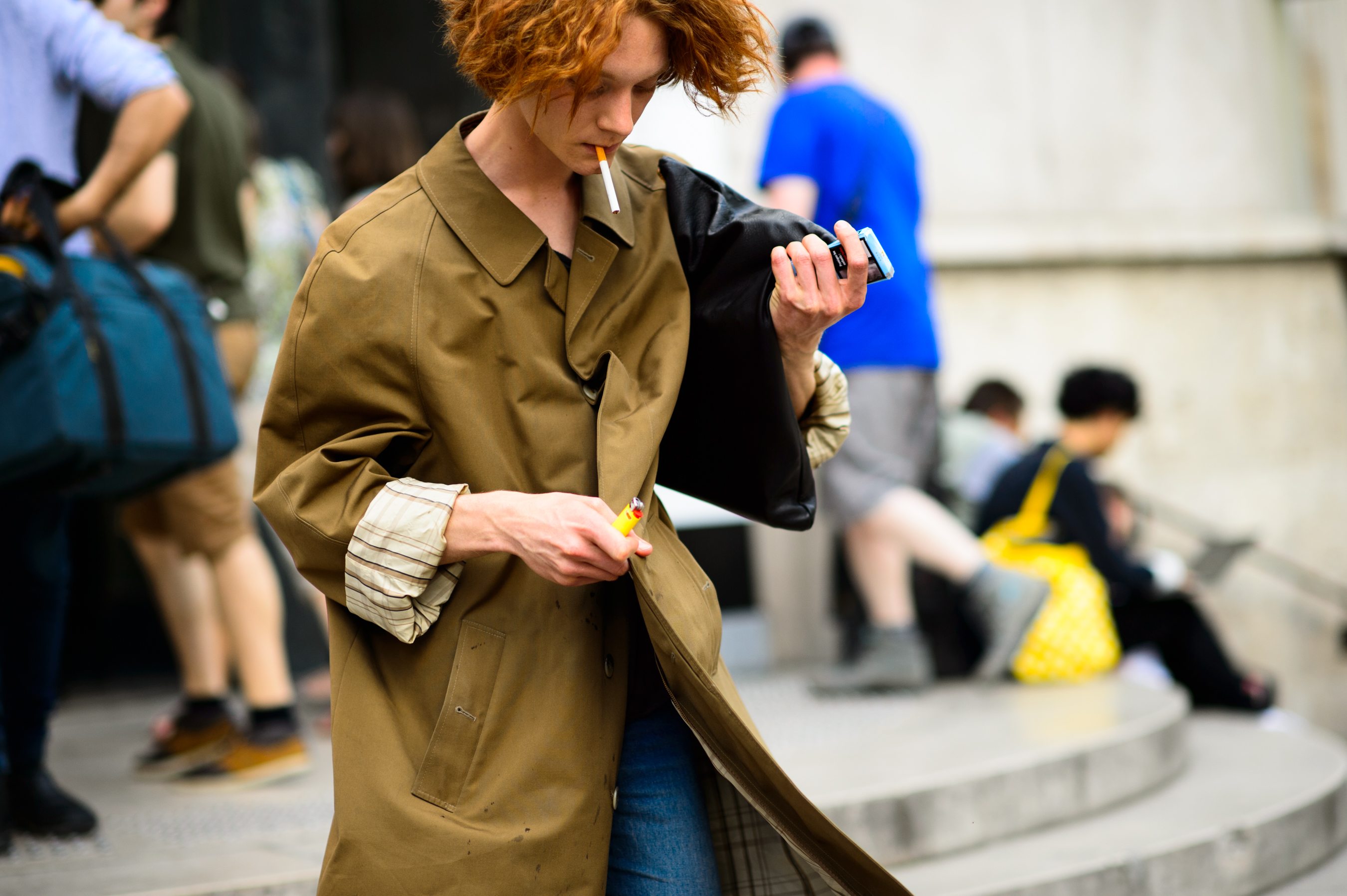 Guest in khaki coat and cigarette leaving the show