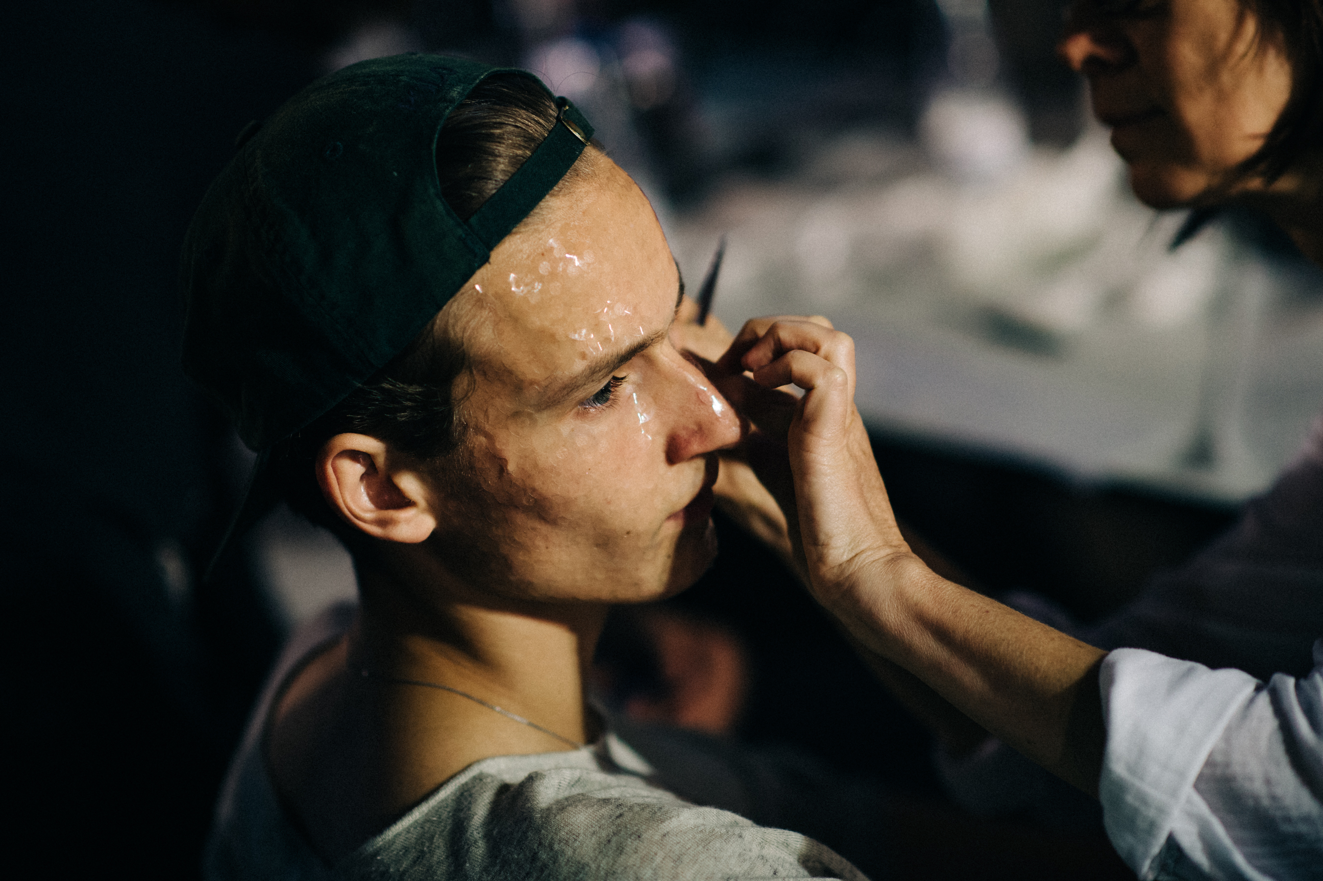 Male model getting his make up before the fashion show