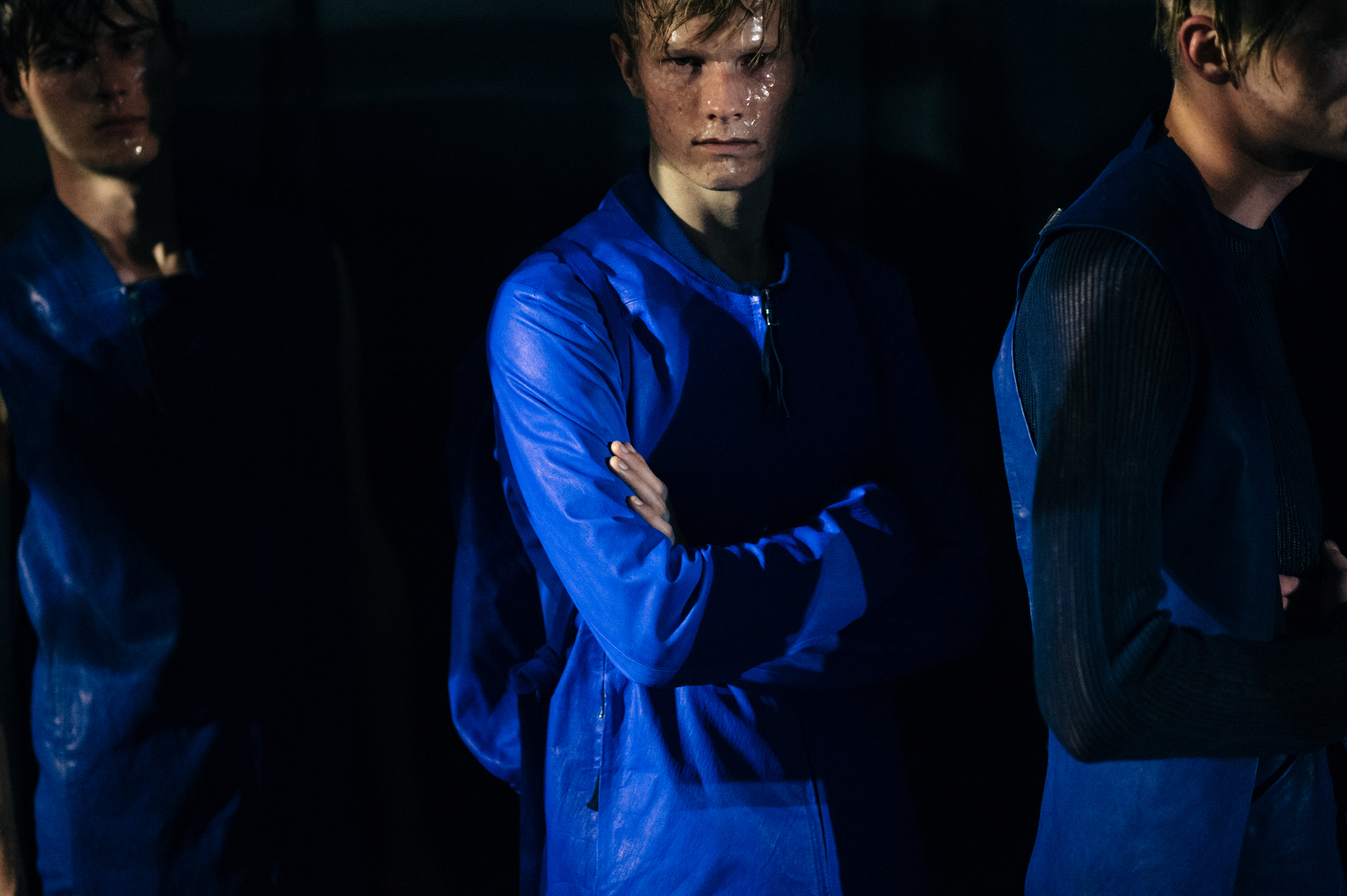 Three male models dressed in blue before the fashion show