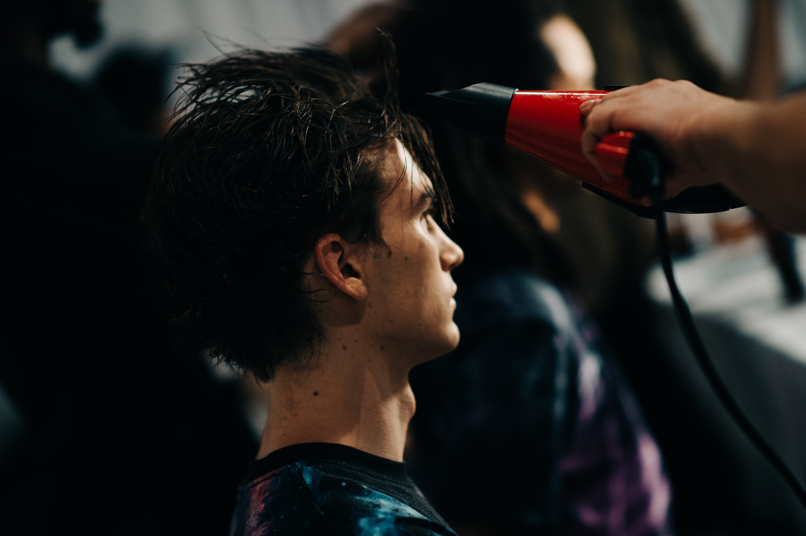 American male model getting hair done before the show