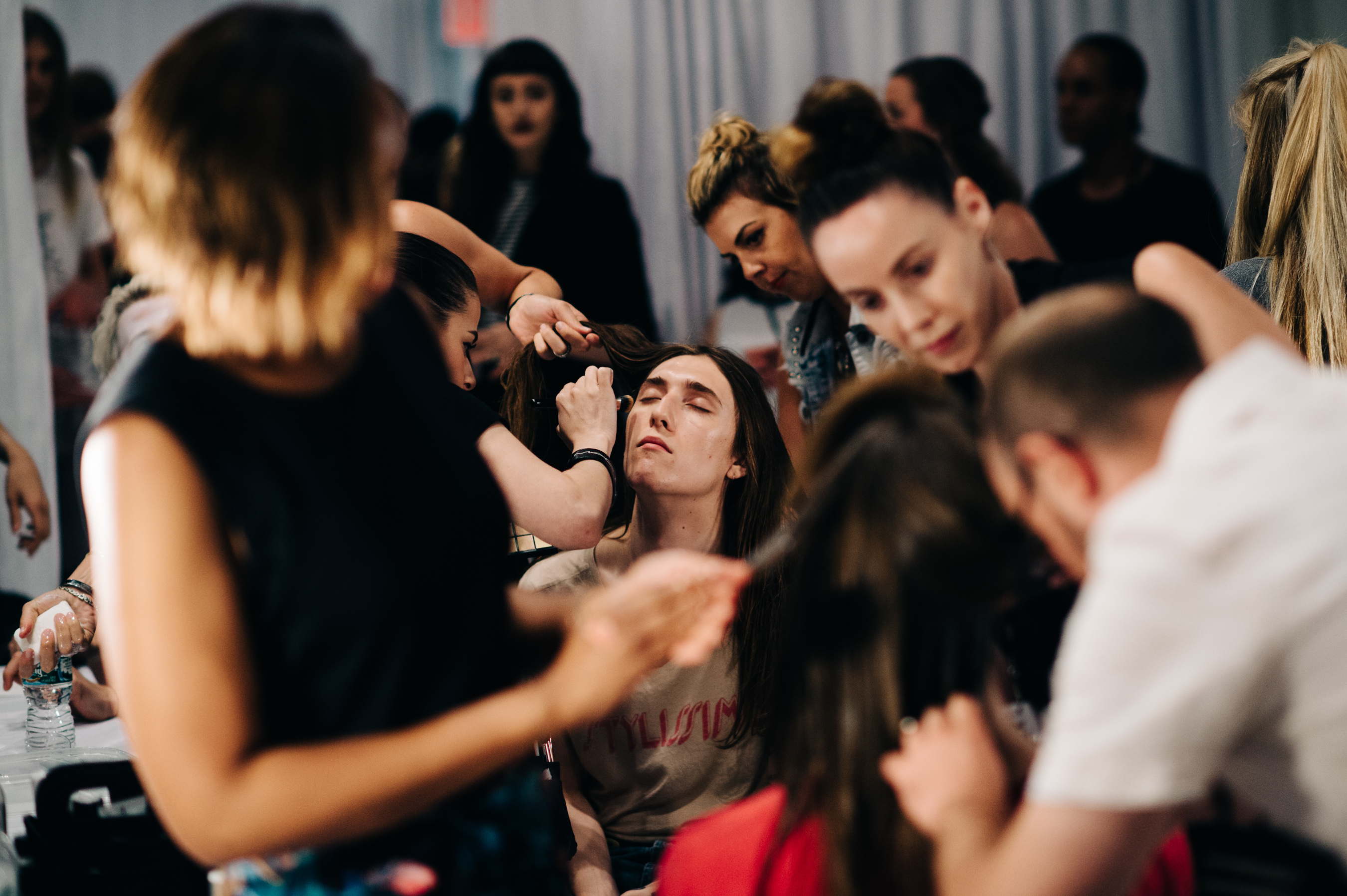 Male model getting make up done before the show