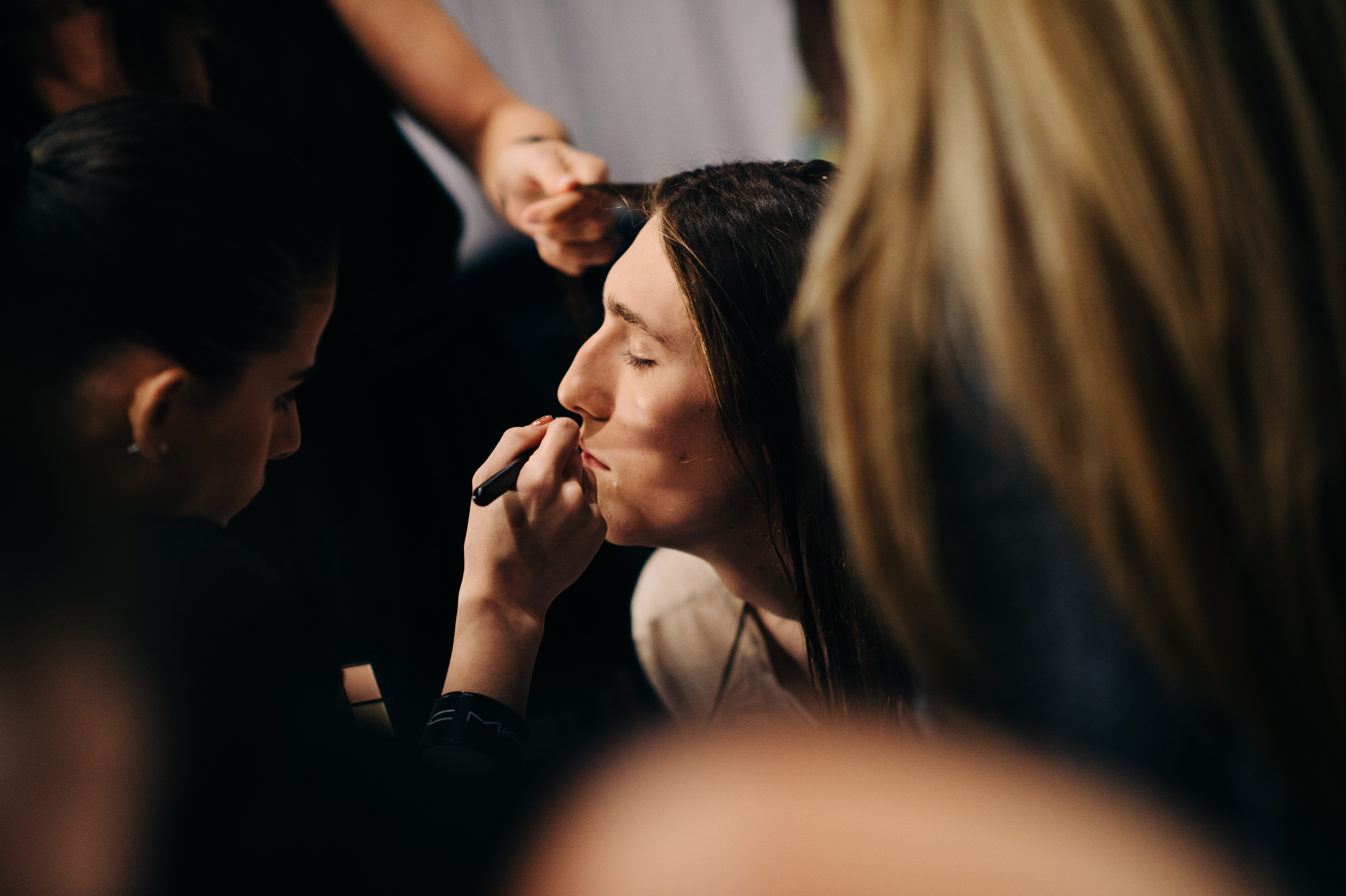 Male model getting make up done before the show