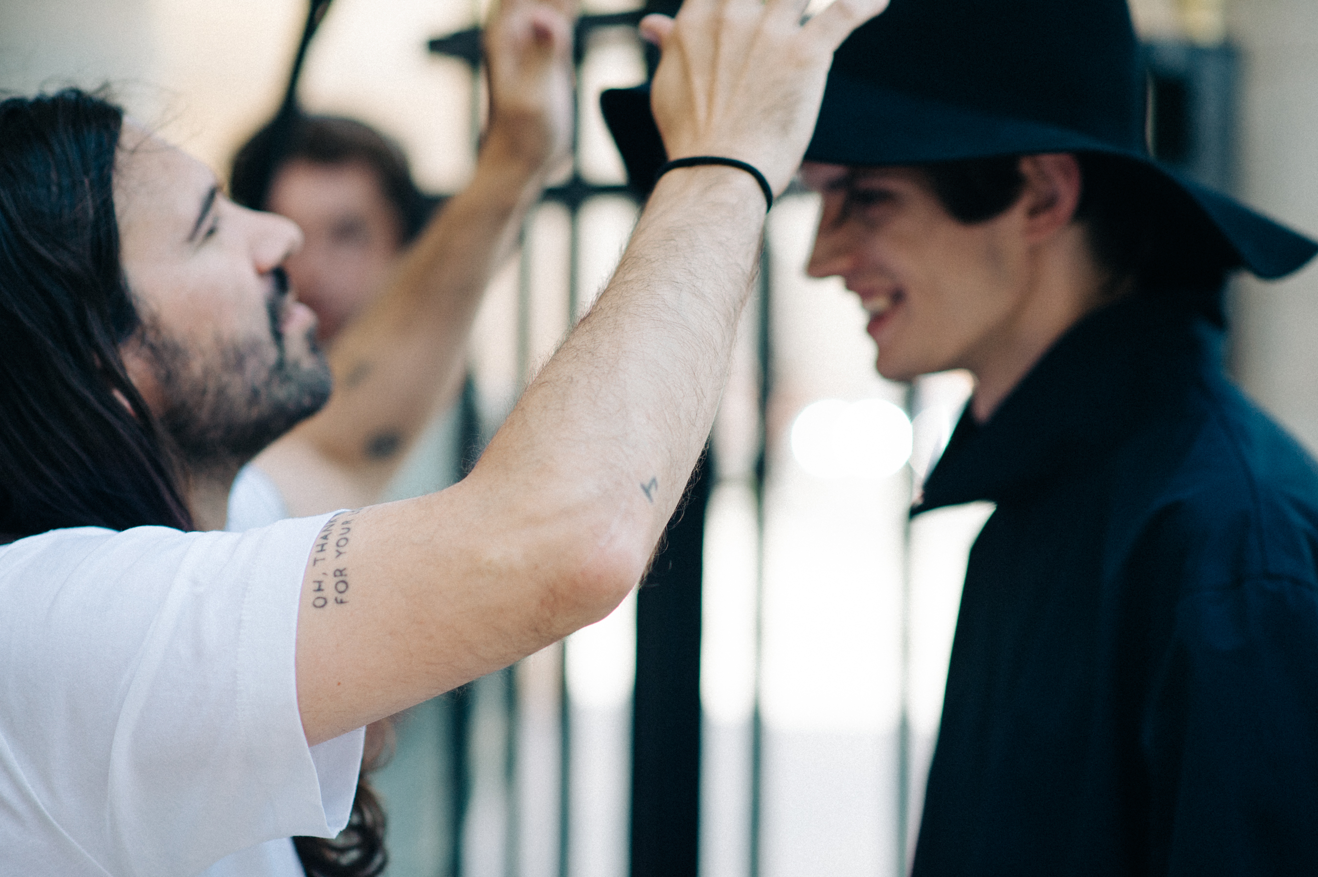 Designer fixing male model's hat before the fashion show