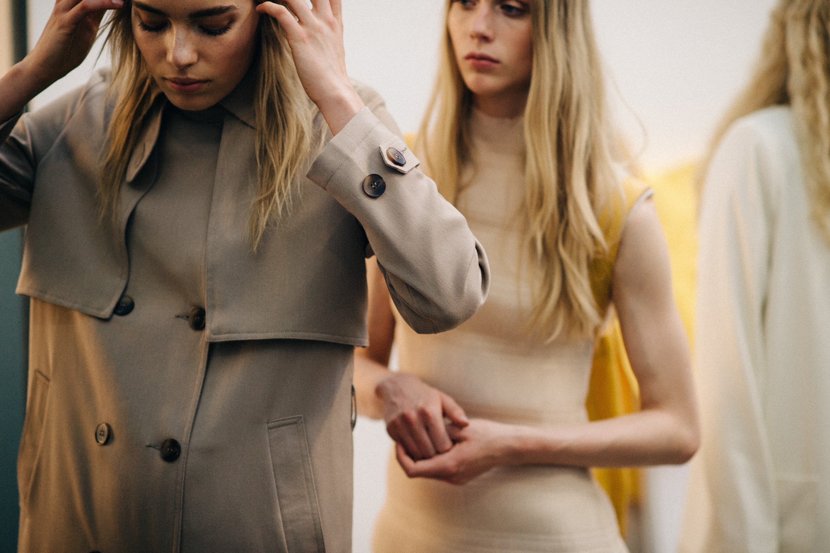 Models getting dressed in light clothes before the show