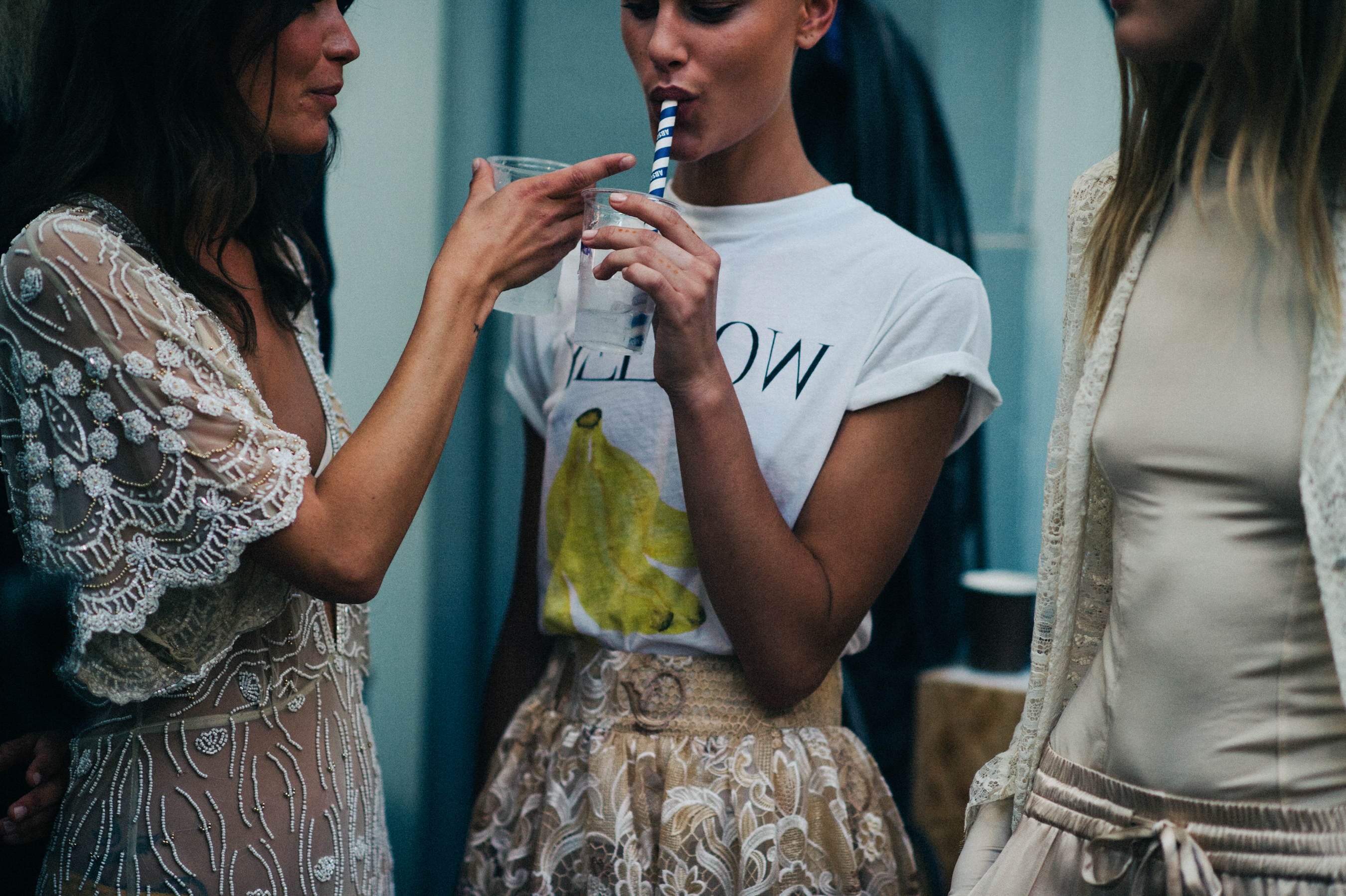 Model with short hair drinking out of straw before the show