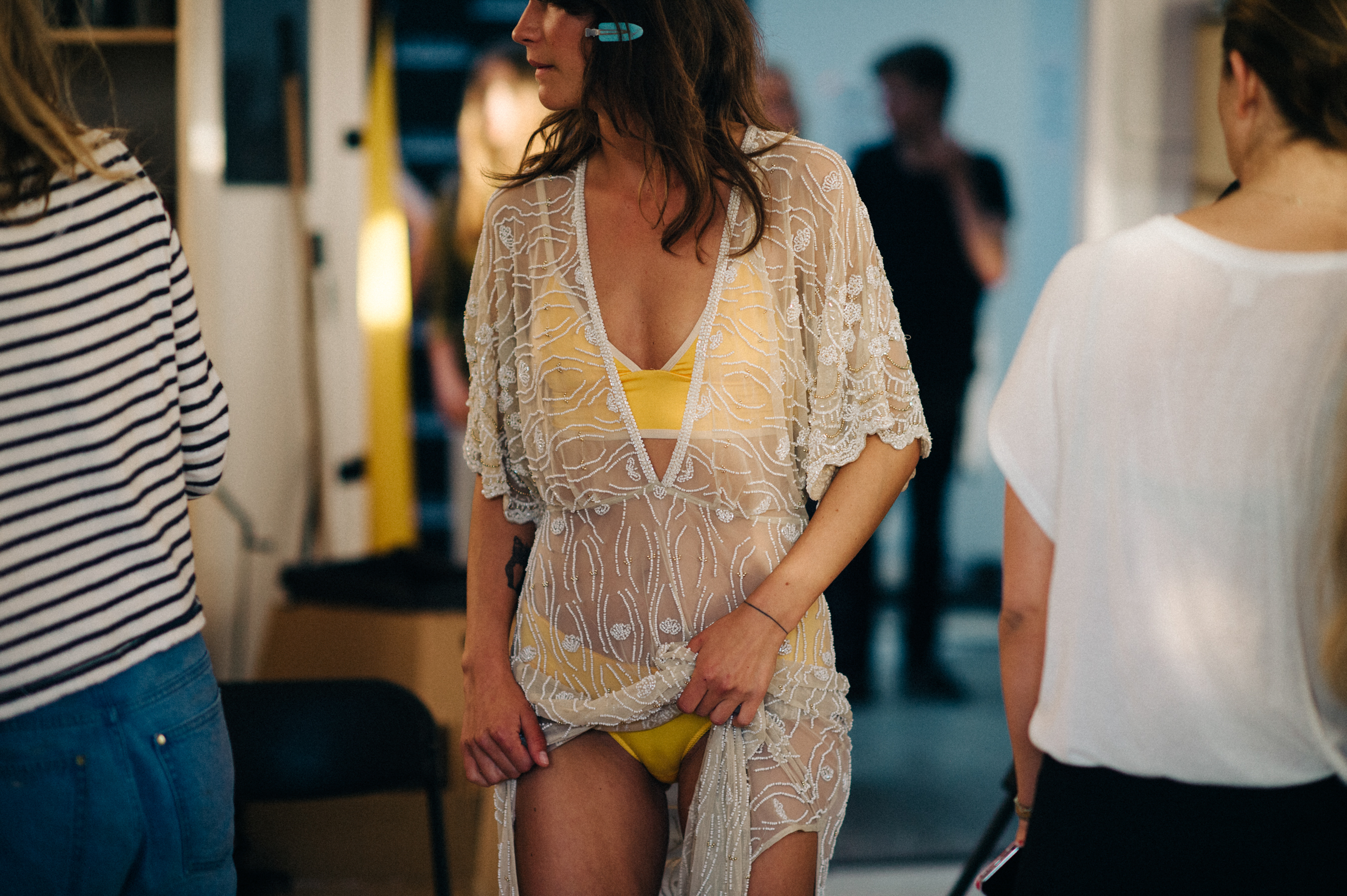 Model in transparent dress and yellow swimming suit before the show