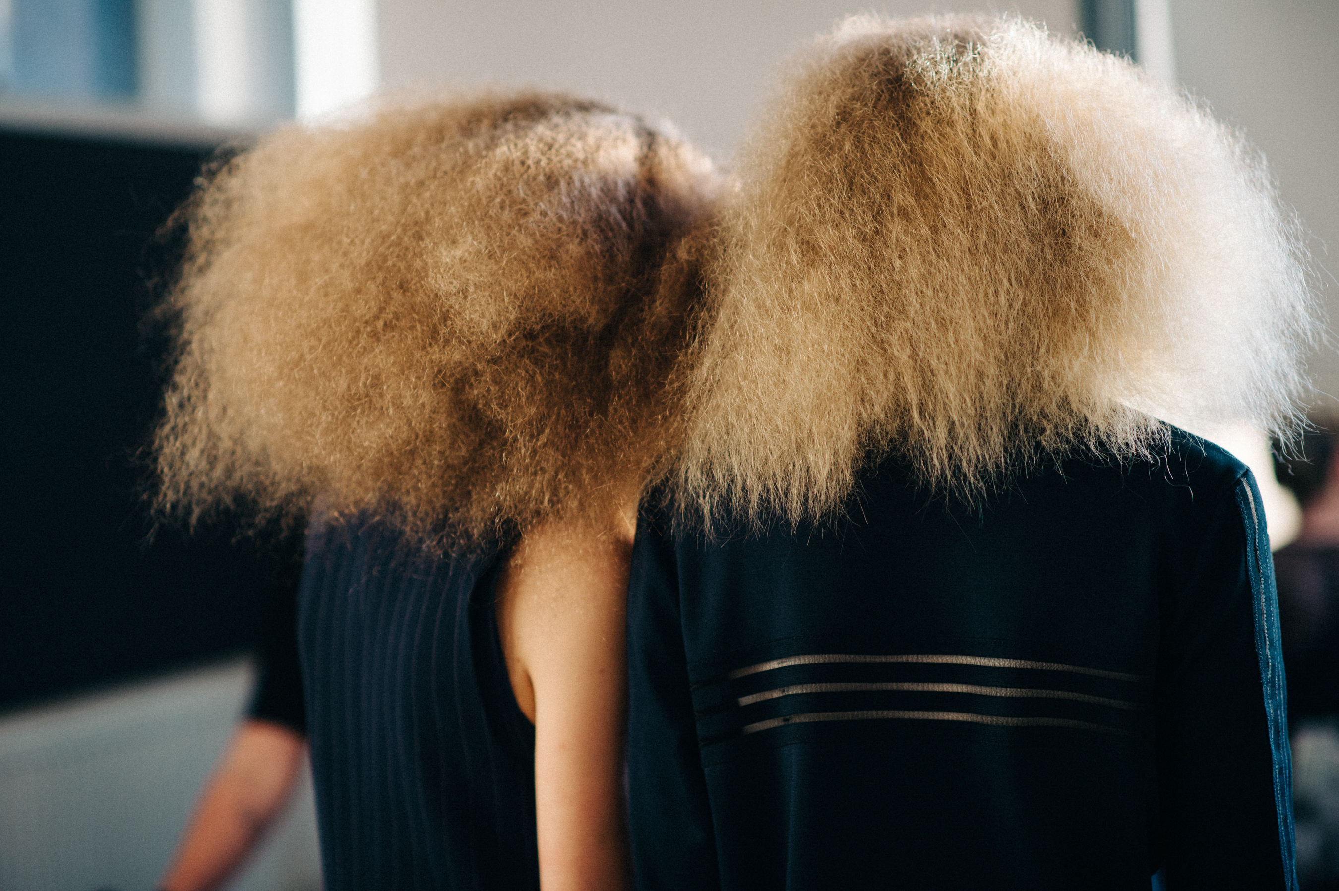 Two models with big curly hair before the show