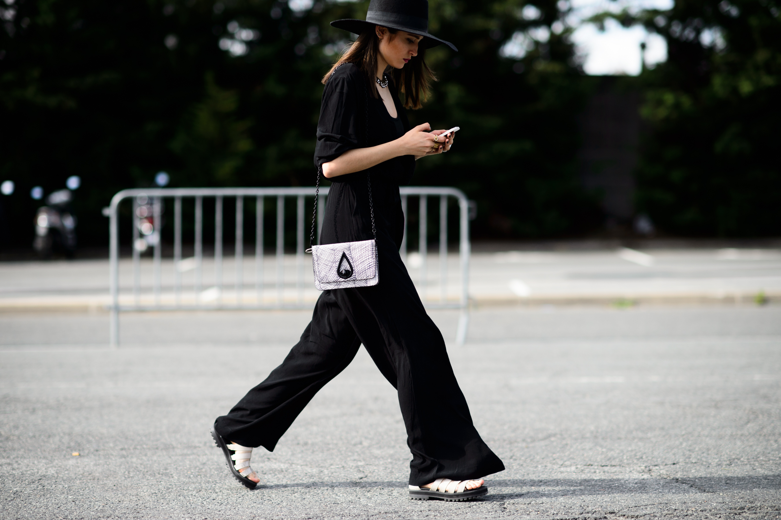Woman in hat and black jumpsuit before Thom Browne show
